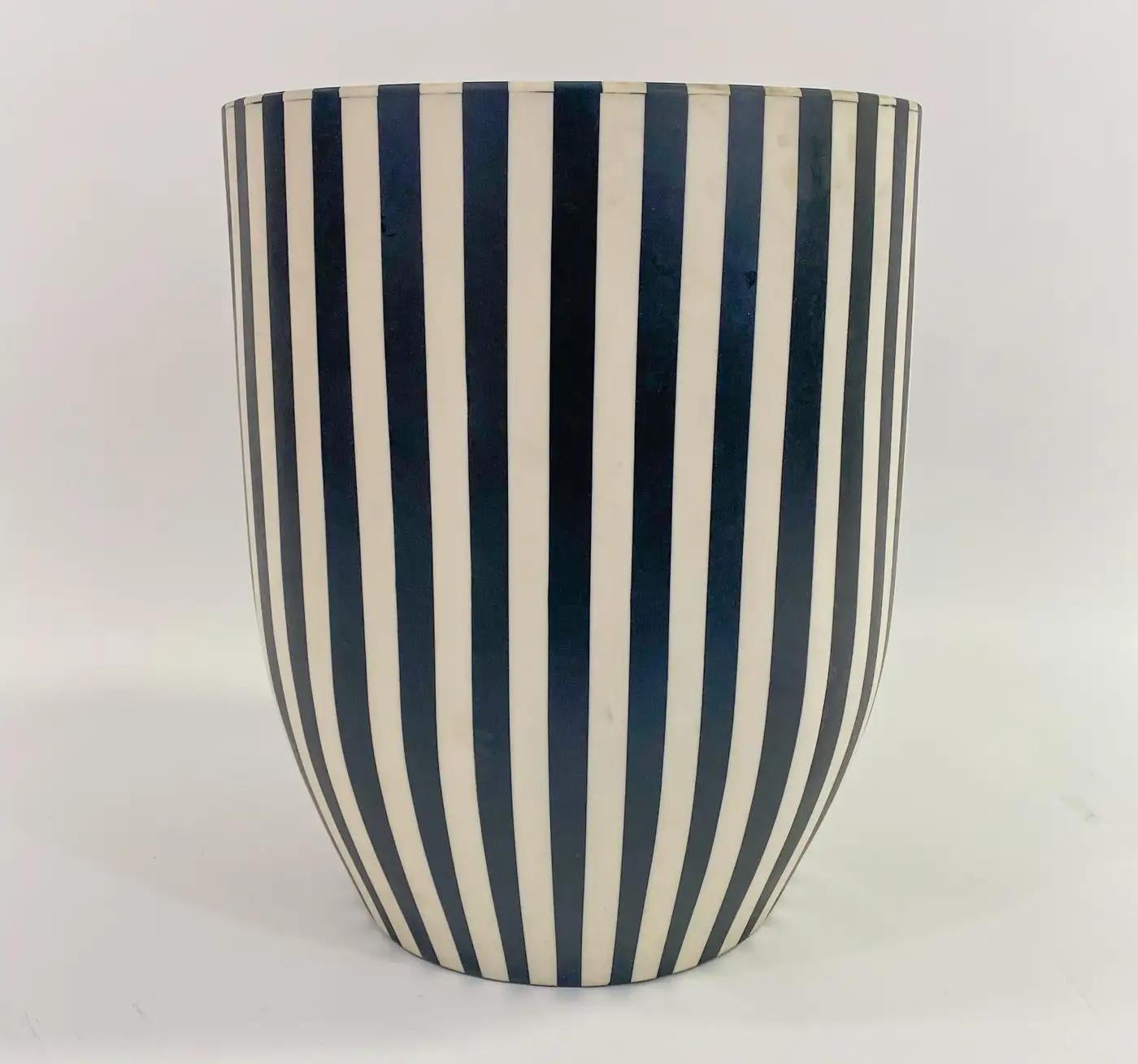 A one of kind Art Deco style black and white side table or stool featuring a striped design. The table is made of quality resin and have a solid and sturdy structure. The sculptural cylindric shaped table has a round top and and narrow base making