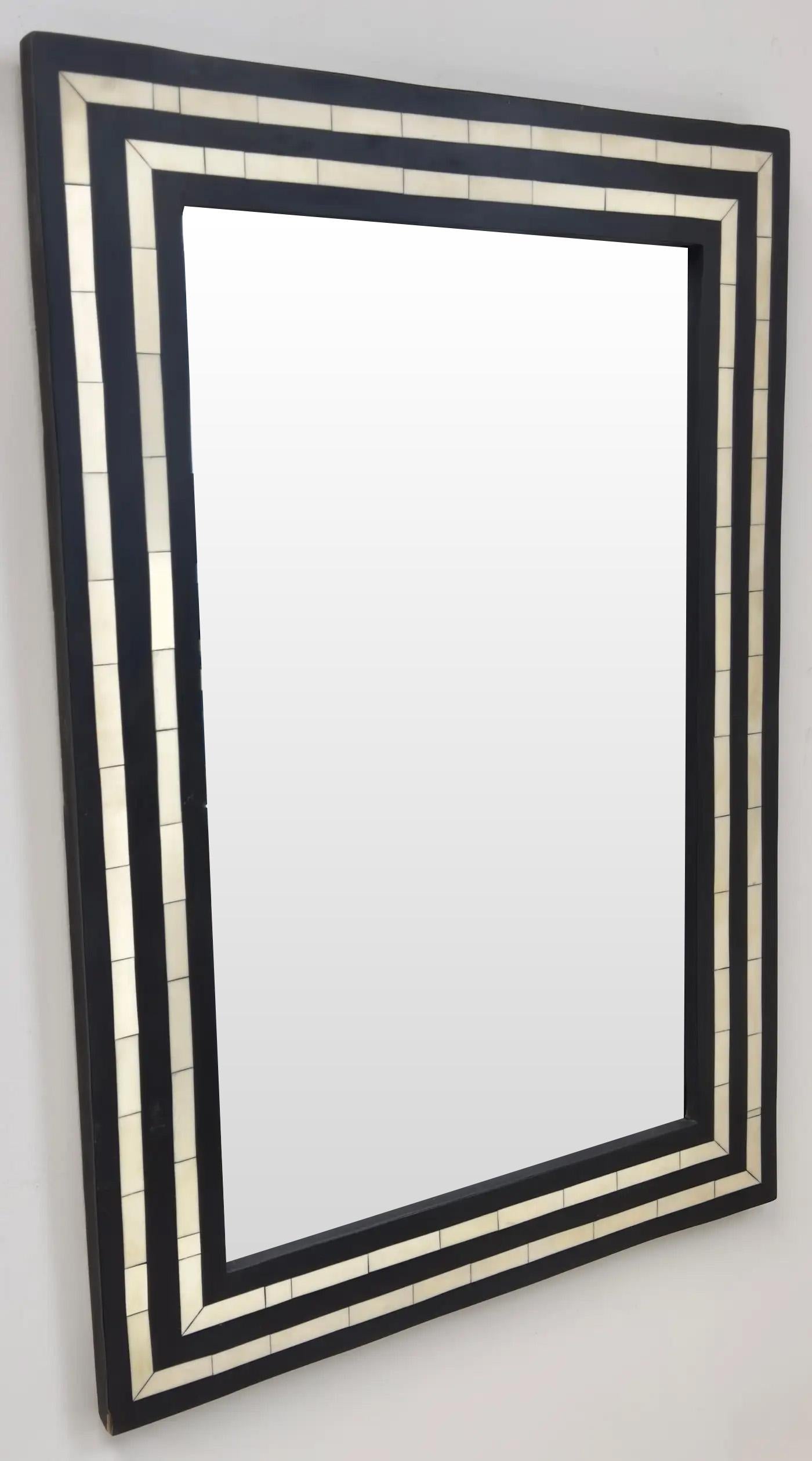
Ein Wand- oder Konsolenspiegel im Art-Déco-Stil, der durch sein kühnes geometrisches Design eine raffinierte Eleganz ausstrahlt. Der aus Harz gefertigte Rahmen zeigt einen raffinierten Kontrast aus schwarzen und weißen Fliesen, die in einer Reihe
