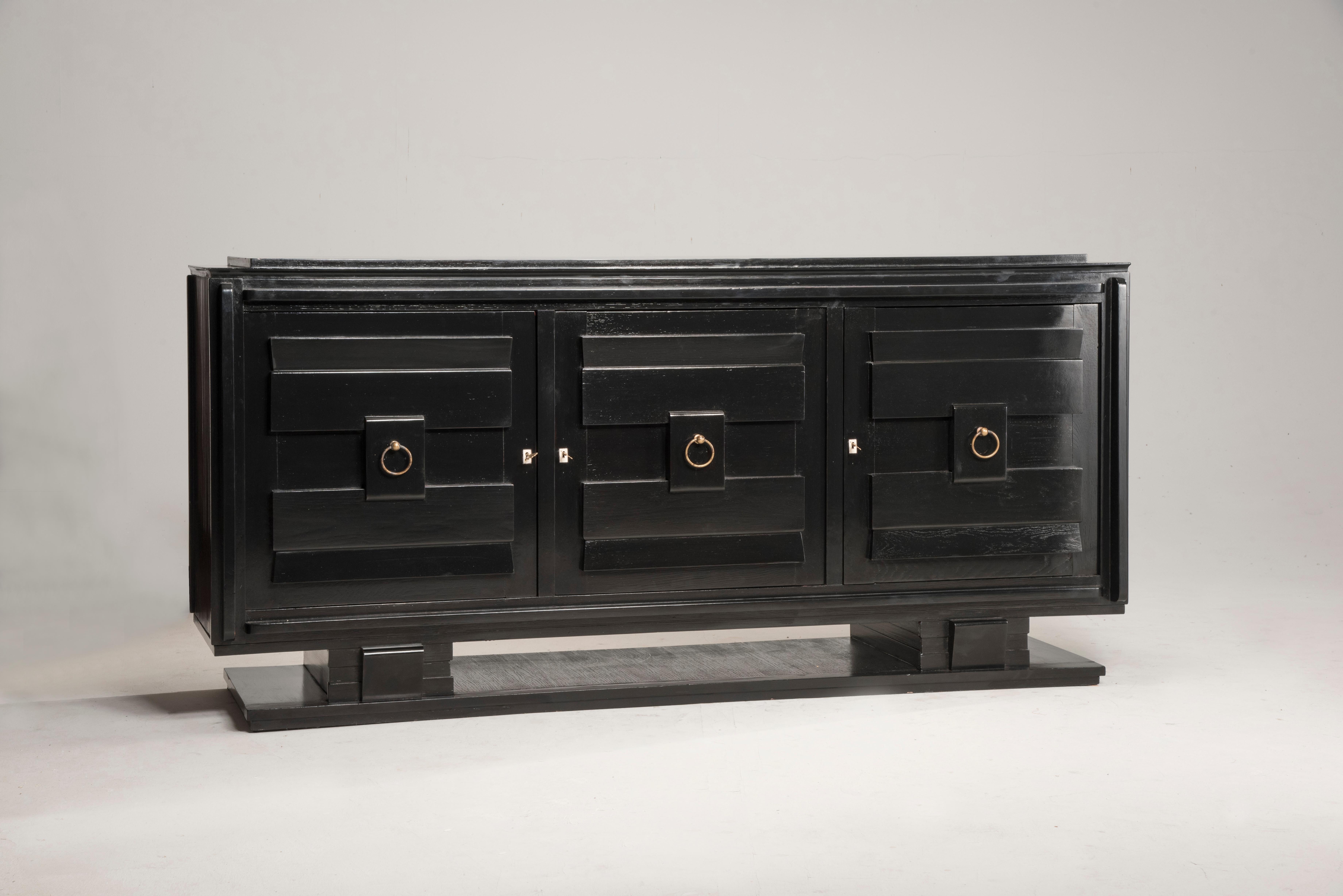 French 1940s Art Deco style black lacquered and crystal top credenza

French Art Deco sideboard. Black lacquer and crystal top. Three doors and brass hardware. Internally the doors are arranged with shelves and one drawer. The top is covered with
