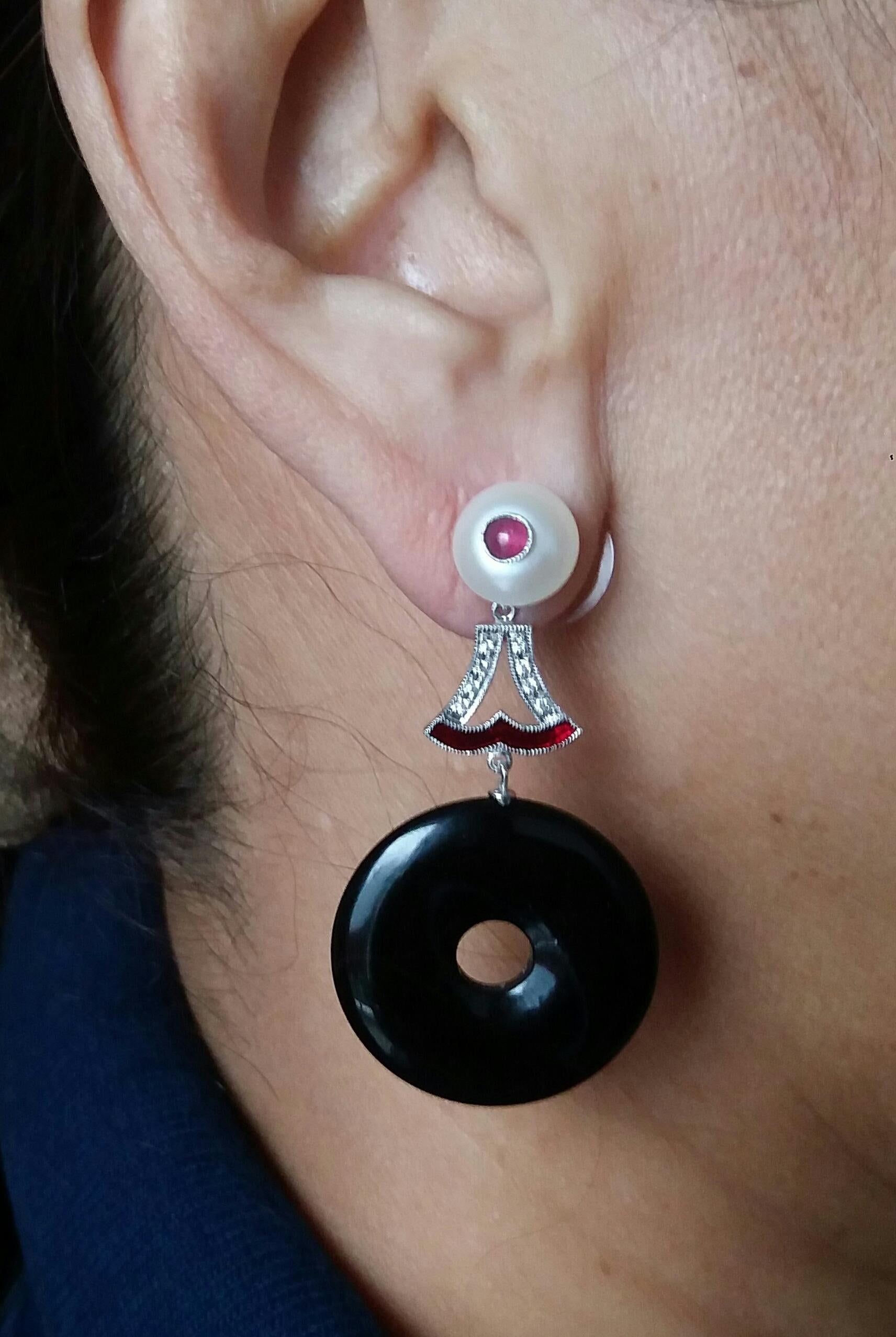 Classic art deco style earrings, the top parts with 2 pearls of 9 mm in diameter with  small ruby round cabochons in the center, the central part consists of 2 elements of white gold ,diamonds and red enamel from which are suspended 2 discs of black