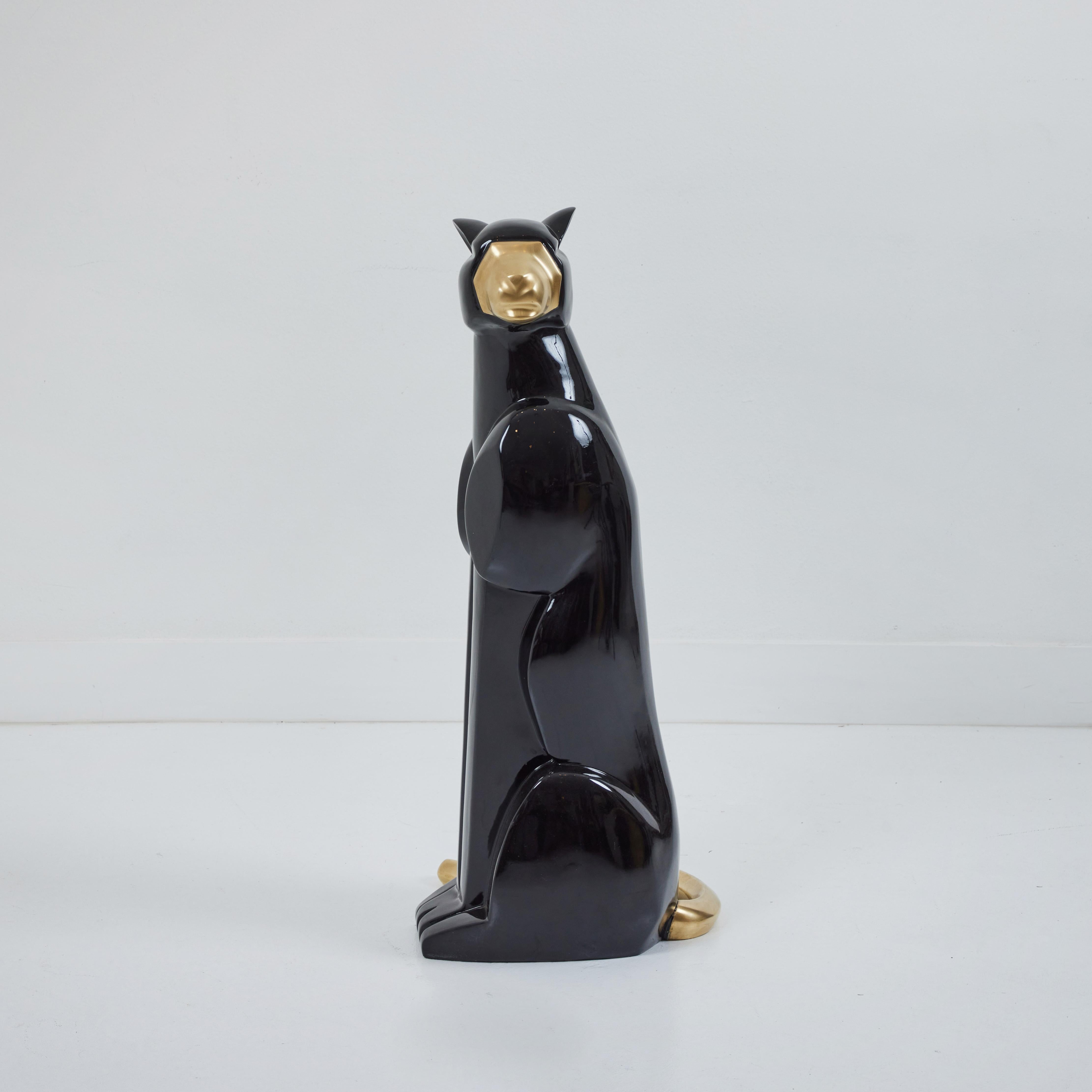 This is a sleek art deco styled black panther with brass details. The panther is in a seated position with its face turned to the left. Cast in fiberglass and lacquered black, this sculpture will definitely draw attention. The skill of the sculptor