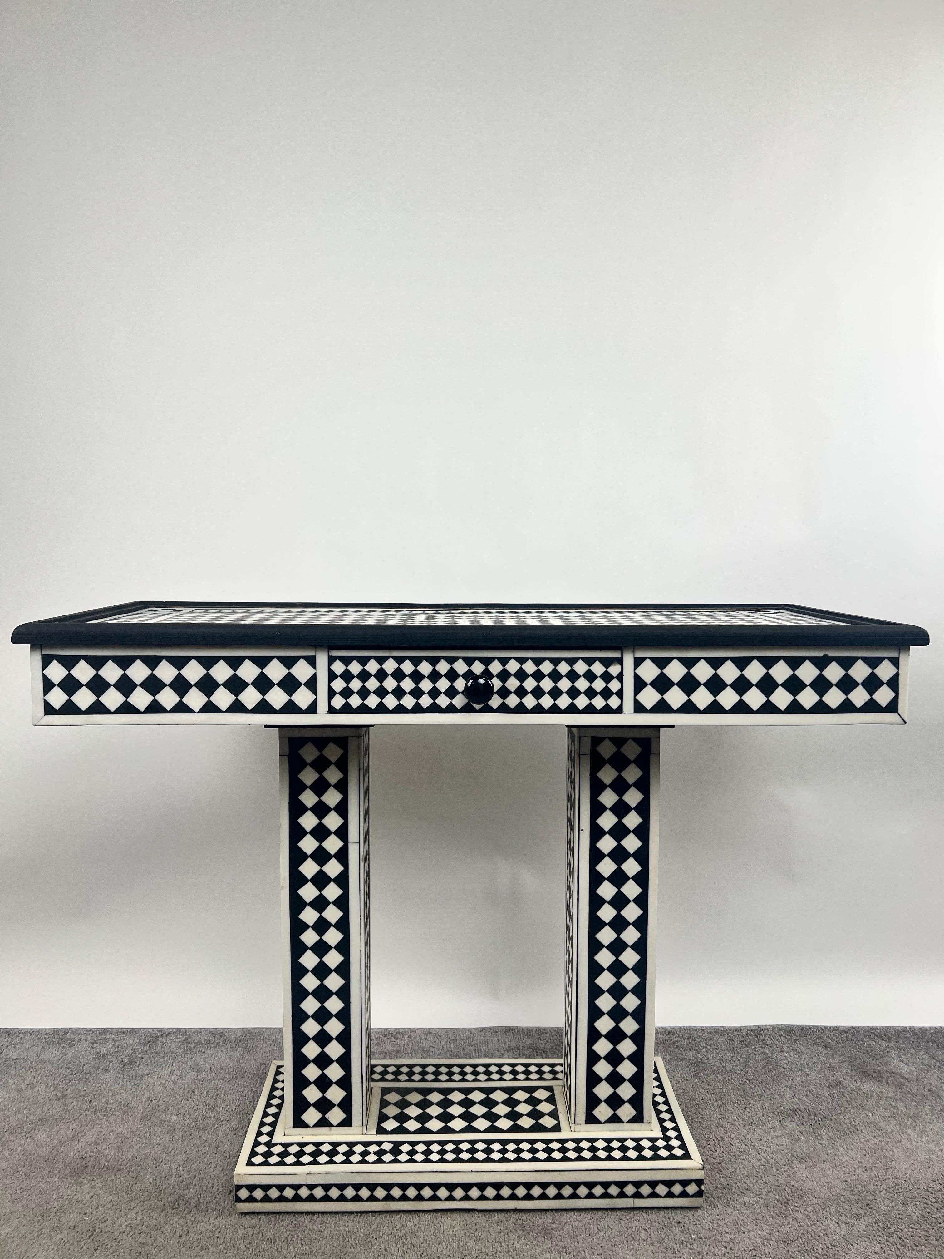 An  Art Deco style black and white console table handmade of high quality resin. 
The console table is a striking fusion of geometric precision and timeless elegance. Its meticulously crafted resin structure is adorned with a bold black and white