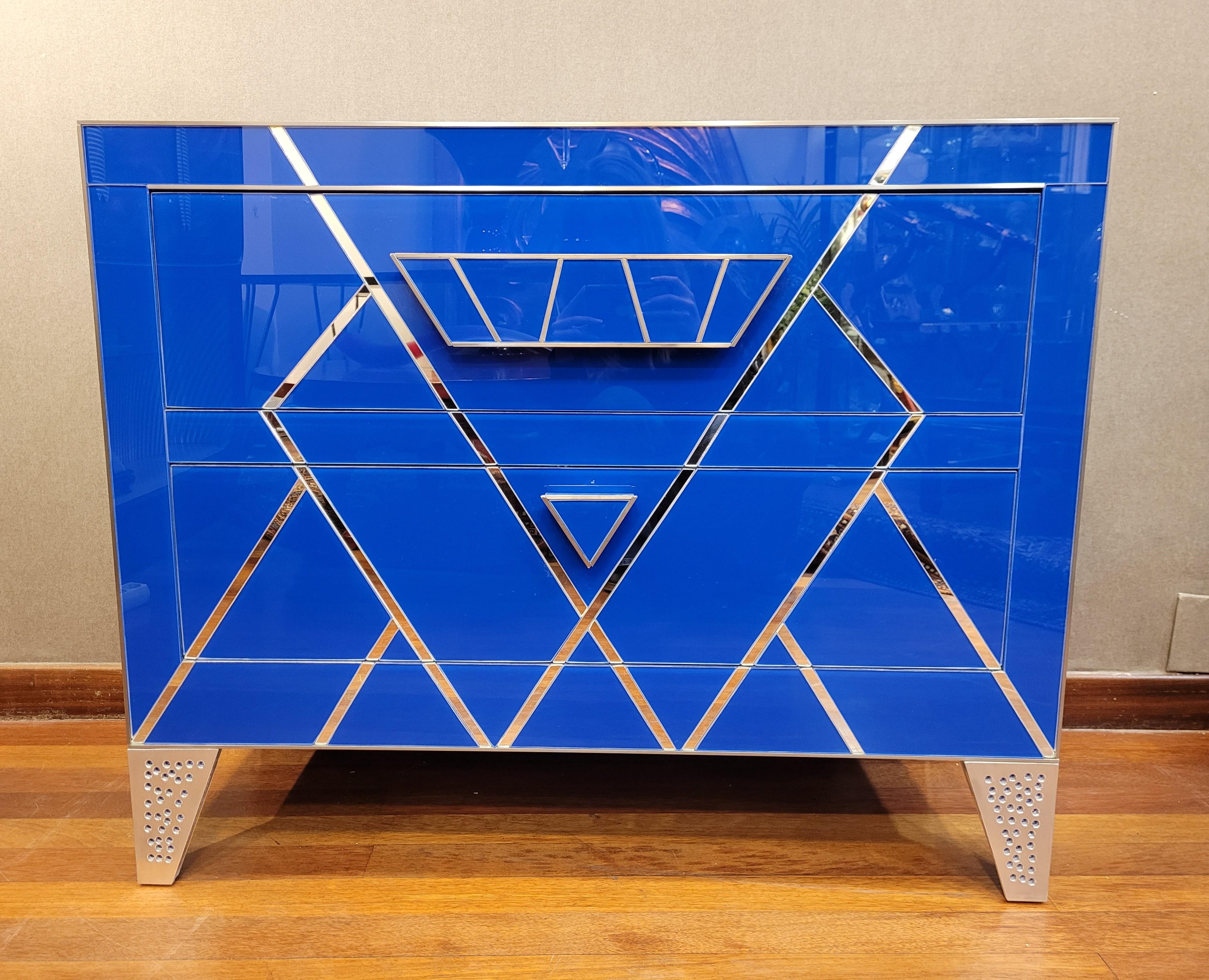 Outstanding pair of chests of drawers made by hand with Italian blue glass plates. Exclusive geometric design, based on triangular shapes and their tangents, which seem to form the silhouette of a diamond on the front. Each chest of drawers is made