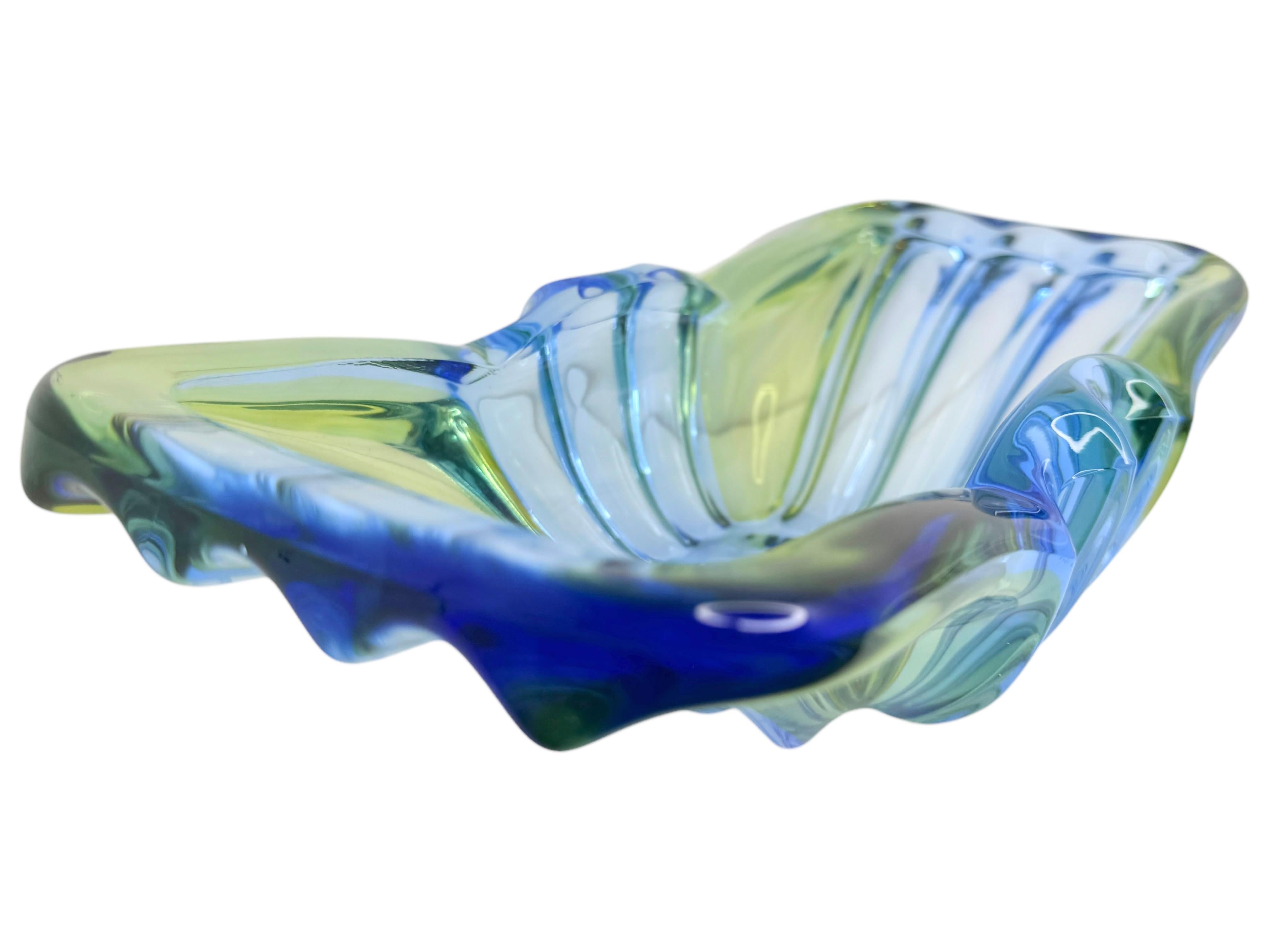 A beautiful centerpiece made of green and blue colored Murano glass. The shape, full of soft curves and rounded tips, fascinates with its incomparable, elegant plasticity and lightness. It was made with the 