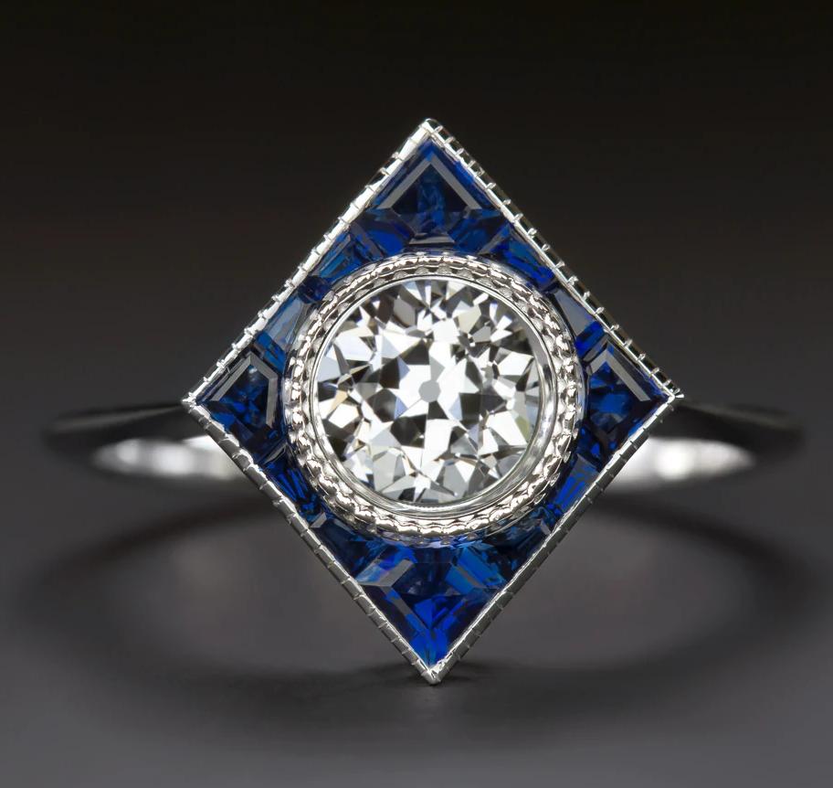 gorgeous ring is a beautifully designed modern twist on an Art Deco era target ring. The chic geometric setting is set with rich blue custom cut natural sapphires. Finished with fine milgrain details.

Eye-catching and classically fashionable, this