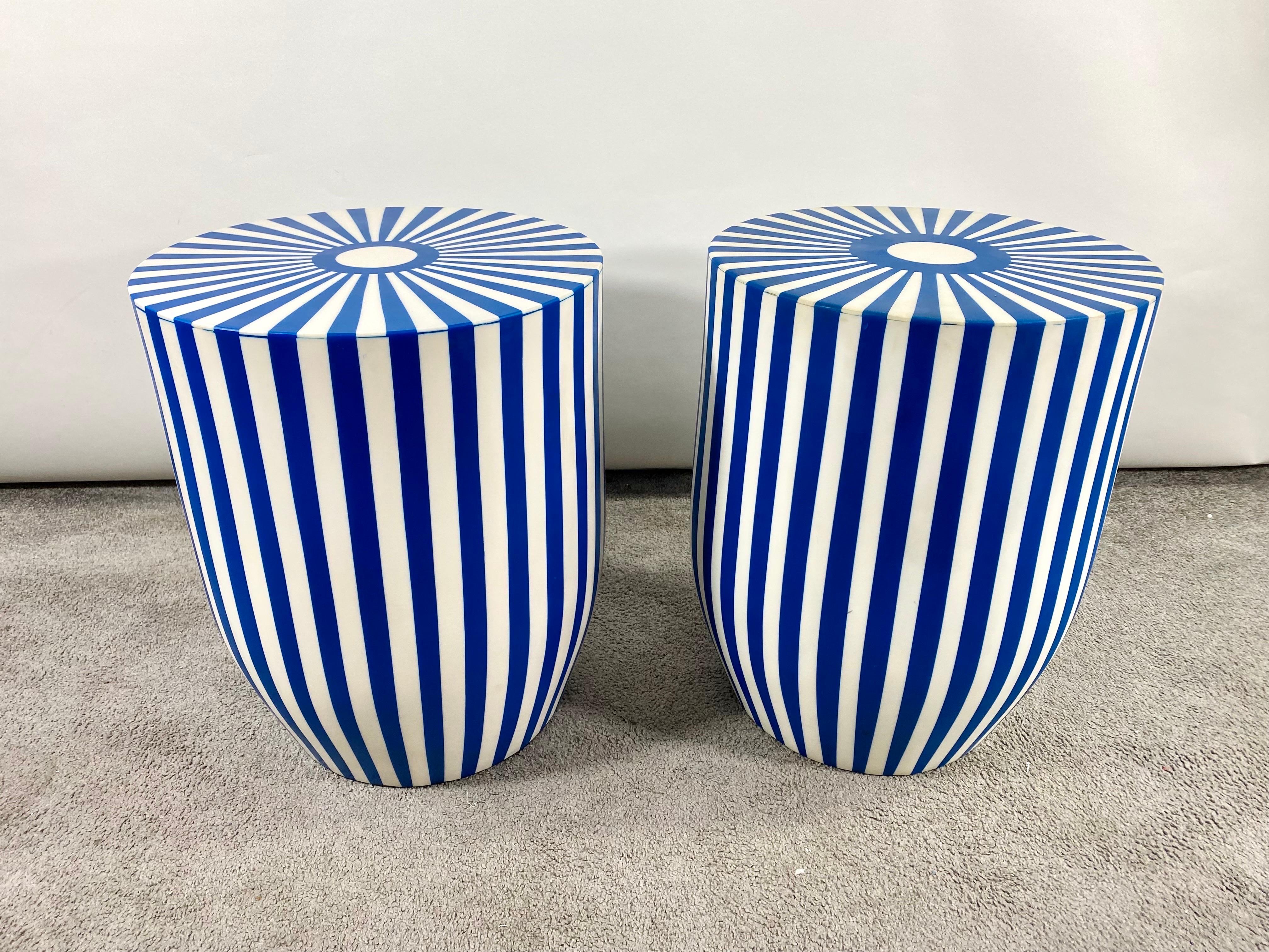 An exquisite pair of Art Deco style blue and white side tables or stools featuring a striped design. The tables are made of quality resin and have a solid and sturdy structure. The sculptural cylindrical shaped tables or stools have a round top and
