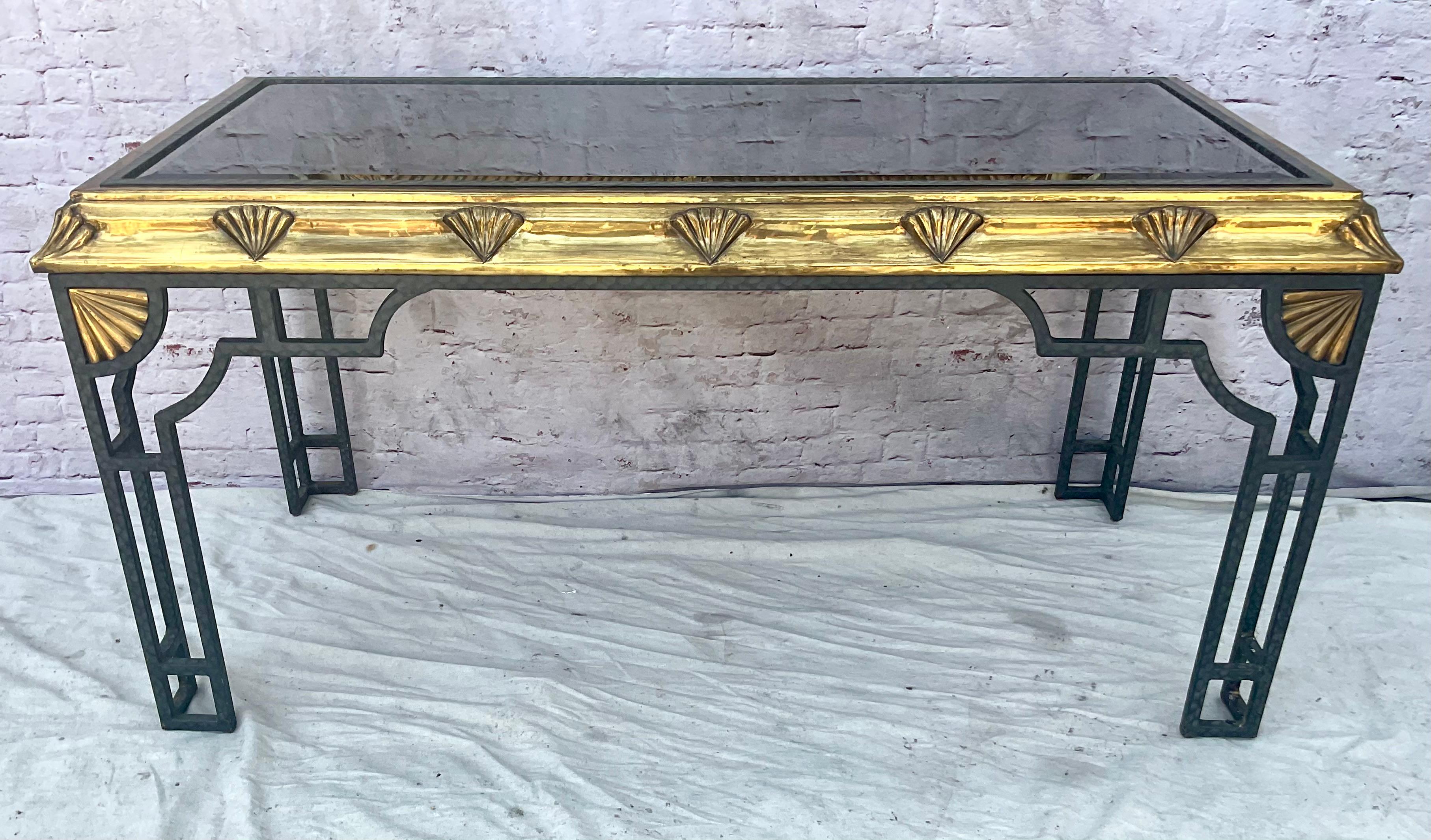 Tavolo consolle in ottone in stile Art Déco del XX secolo con motivo a conchiglia. Questo tavolo consolle ha linee decise e forme filanti, con un motivo di conchiglie a ventaglio lungo il grembiule e gli angoli. L'ottone conferisce al pezzo una