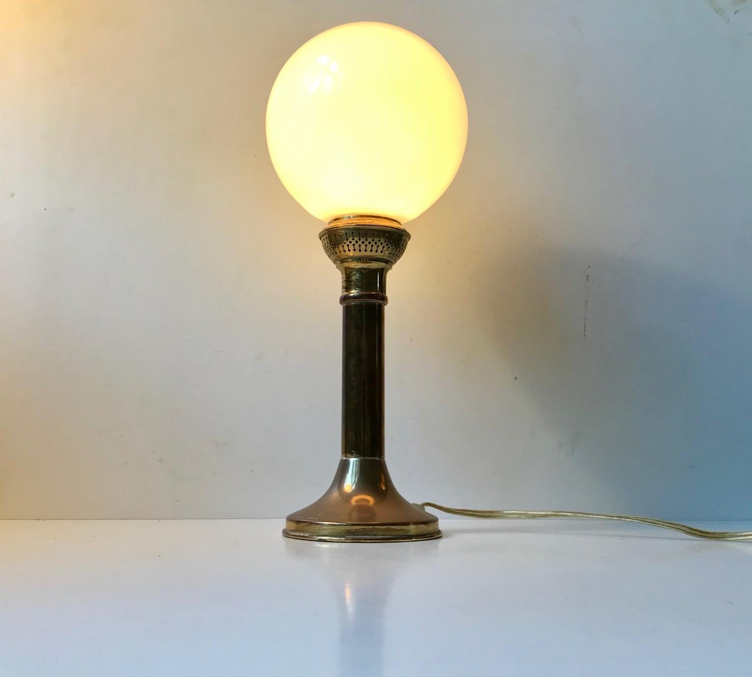 Table lamp composed of a brass base mounted with spherical shade in opaline glass. Anonymous Scandinavian maker/design in the style of Uno and Osten Kristiansson.