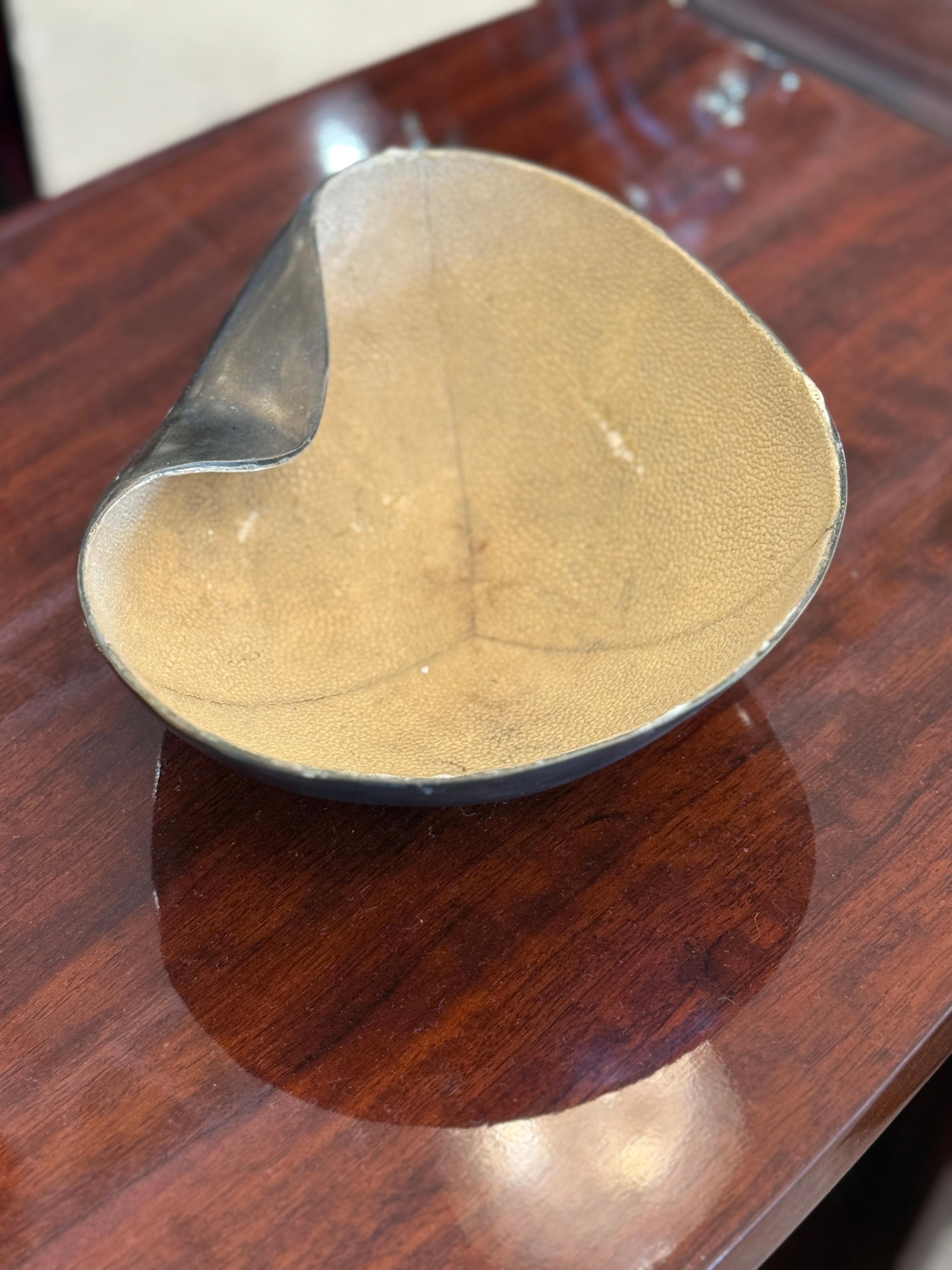 A Bronze bowl with a Beige color Shagreen lining in the inside.  This piece is signed by R&Y Augousti Paris.