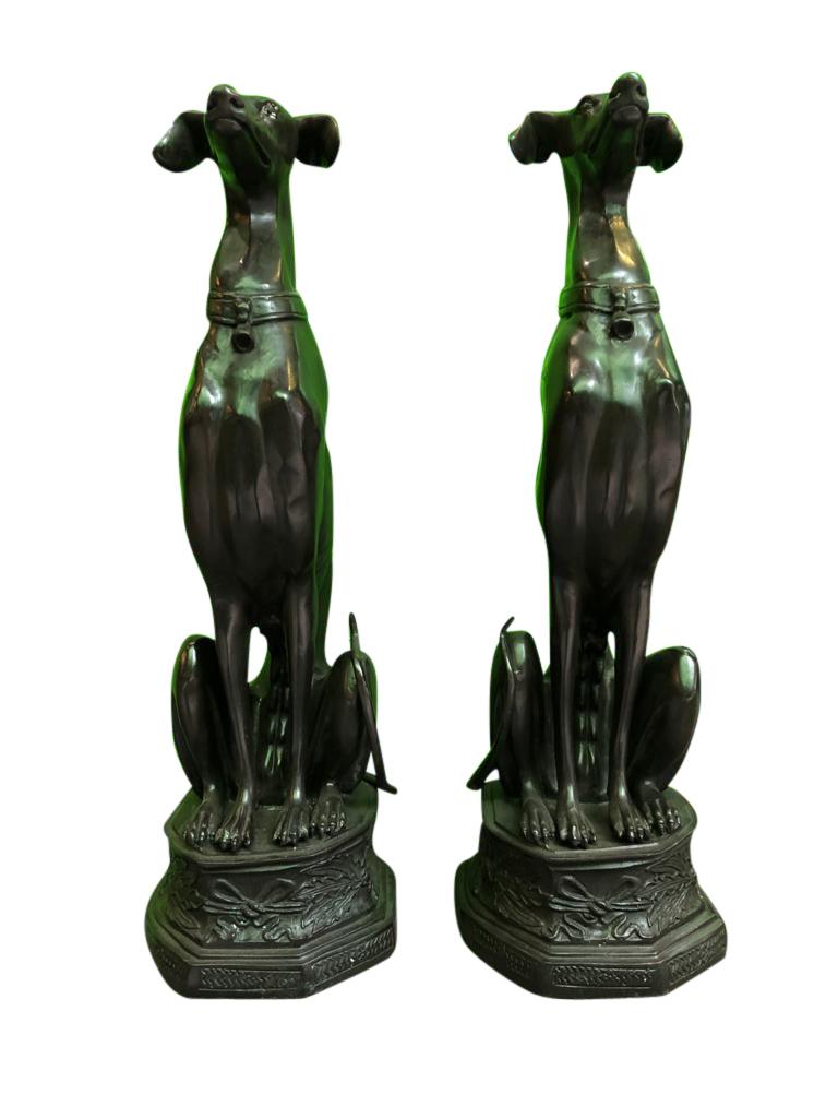 A pair of Art Deco style bronze sitting greyhound dogs on bases, 20th century. The beautiful pair of whippet dogs are sitting in the upright guard dog position. These truly stunning pieces are made from bronze and boast exquisite detail and