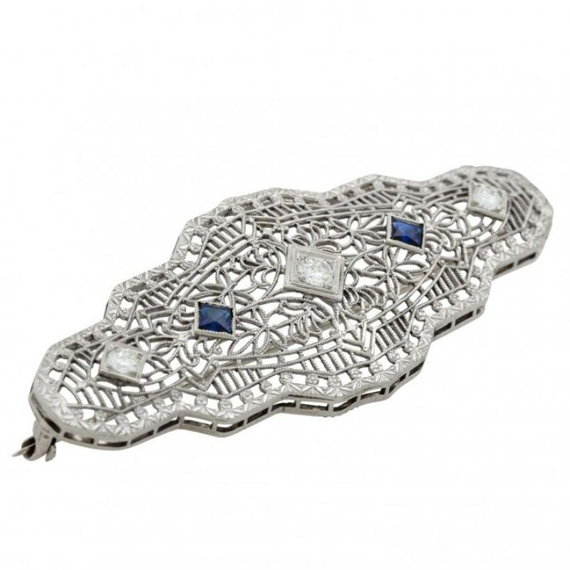 Art Deco style brooch with 3 old European cut diamonds totaling approx. 0.28 ct, good color and clarity, 2 synthetic sapphires, WG 14K/platinum, L: approx. 6 cm, W: approx. 2.5 cm, Exceptionally fine and detailed handwork with engraving.

Brooch,