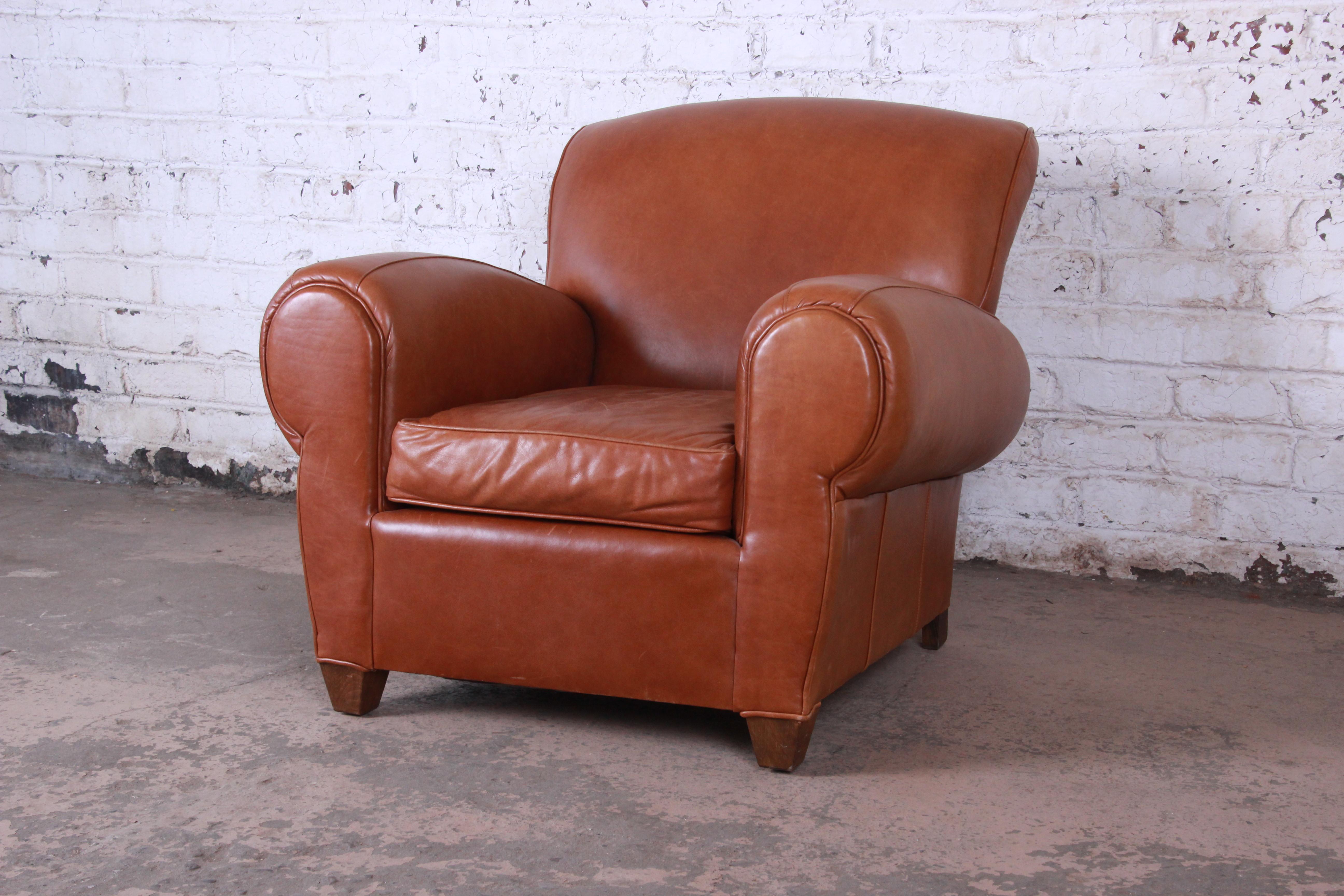 A stylish and comfortable brown leather club chair by Mitchell Gold. The chair features soft high-end brown leather and a beautiful Art Deco design. The leather shows minor surface wear from age and use, but overall the chair is in very good