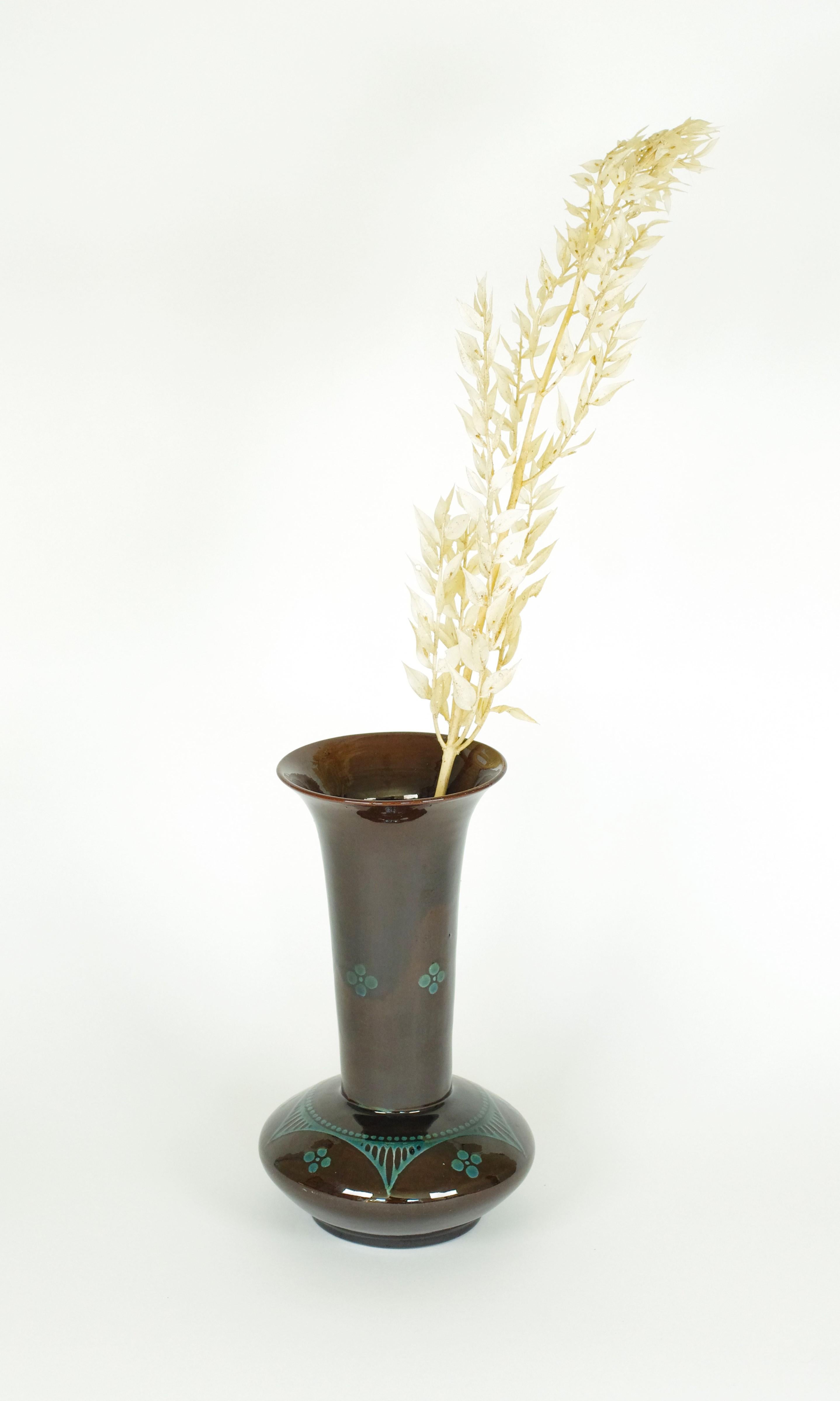 Descrizione del prodotto:
Questo vaso, di origine sconosciuta, presenta un simpatico motivo dipinto in stile art déco. Il vaso ha una base ovale e un collo molto lungo che si allarga in cima. Il motivo turchese del vaso si sposa molto bene con il