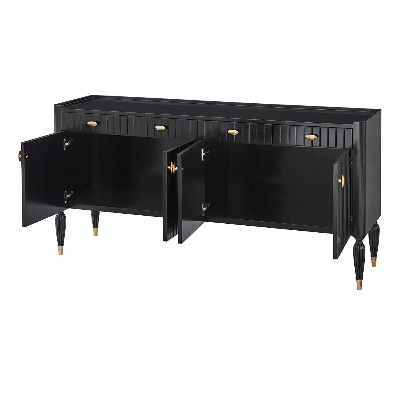 An Art Deco sideboard buffet. Channeled paneled design conceived with four drawers and doors, detailed with oval brass finished handles. The sideboard top is ready to serve with a three-quarter gallery. Lobed reeded tapered legs with brass