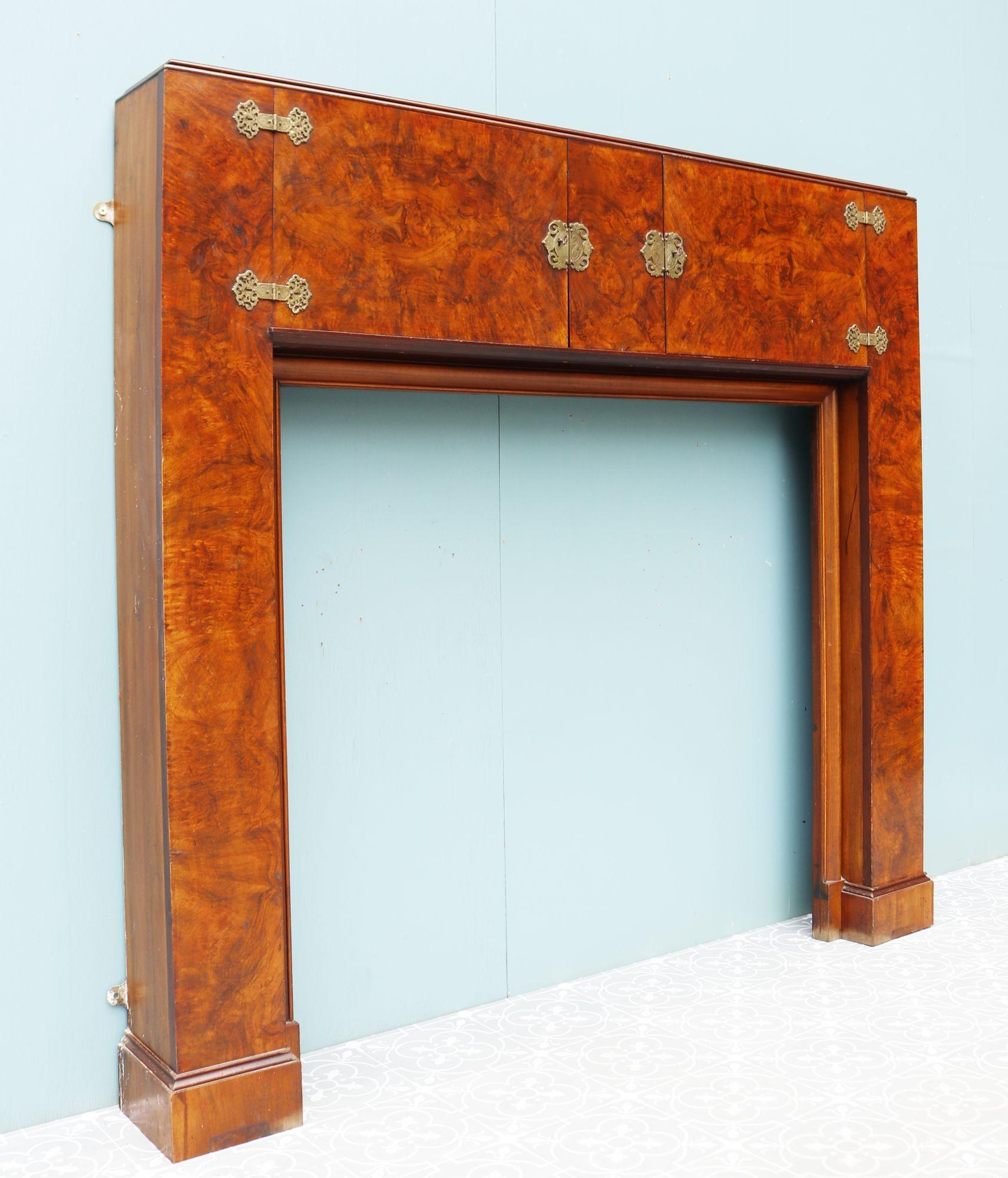 Art Deco style burr walnut fireplace. An Art Deco fire surround with mirrored cabinets and ornate brass fittings. The cabinet comes with two keys. The stye is typical of the early 20th century Art Deco movement with beautifully finished Walnut.
