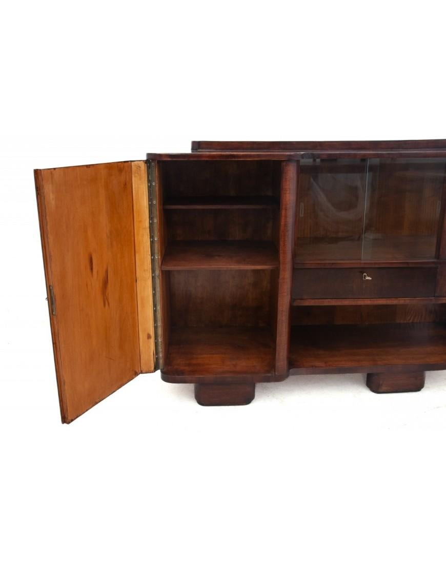 A small, elegant cabinet in the Art Deco style

Origin: Germany, 1940s

Walnut wood finished with glossy polish

Shape characteristic of the Art Deco style, semi-circular side and sliding glass front.

dimensions :

height 92cm width 130cm depth 48cm