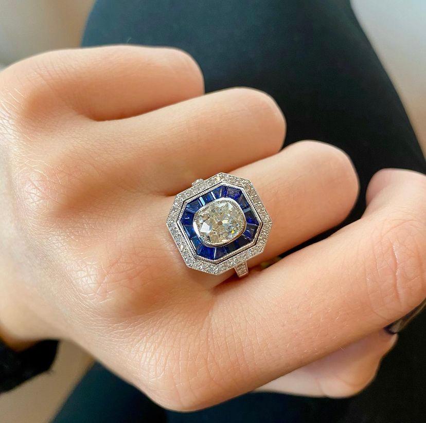 Ring aus 18-karätigem Gold, inspiriert von der Art déco-Zeit. 
Ring besetzt mit einem zentralen Diamanten aus einer alten Mine von 1,38 Karat (Farbe I - Reinheit Si1) und 0,35 Karat Diamanten im 8/8-Schliff und kalibrierten blauen Ceylon-Saphiren.