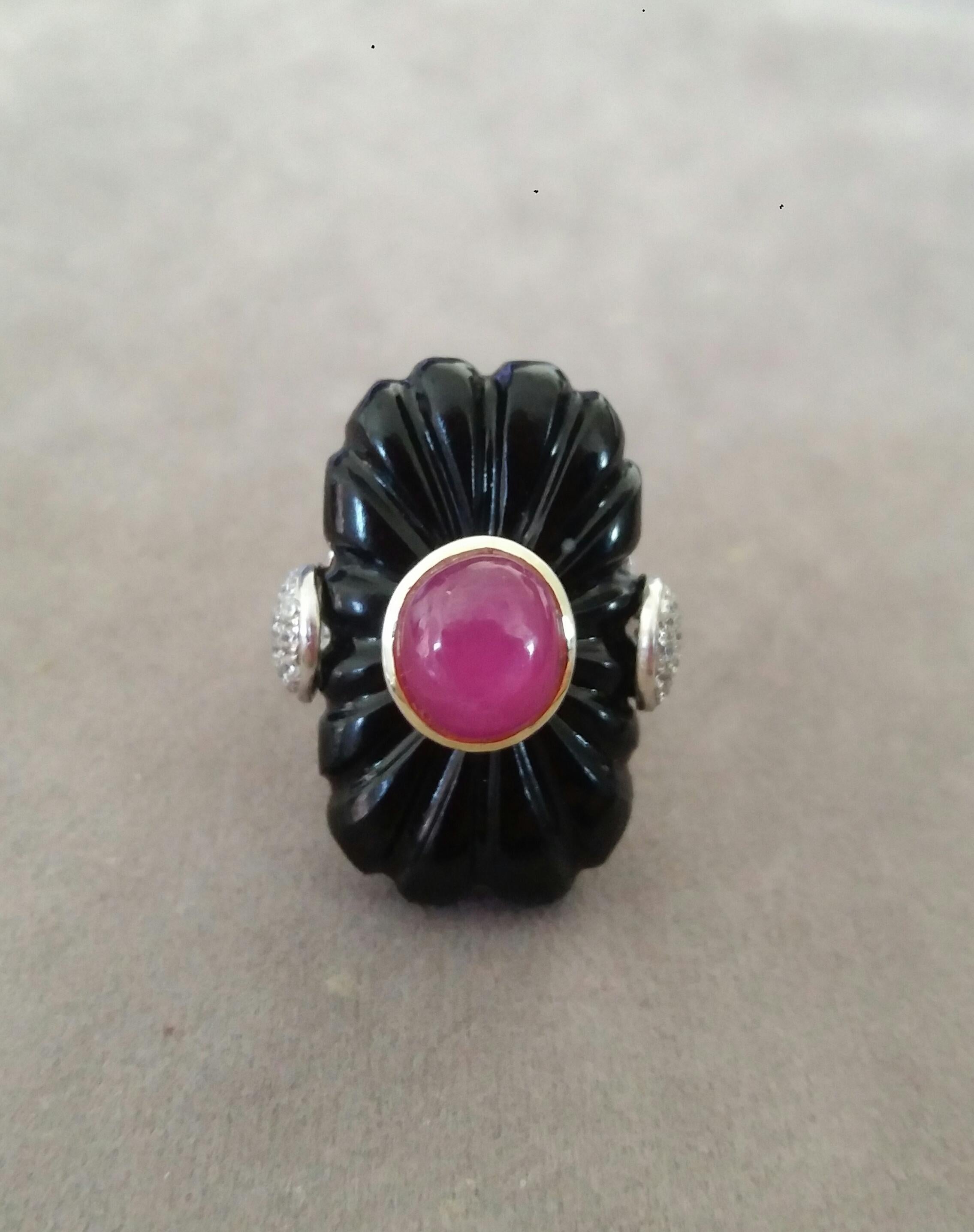 Classic and elegant ring composed of an engraved Black Onyx Classic surmounted by an Oval Ruby Cabochon measuring 8 x 10 mm set in a 14K yellow gold......The shank is in 14k White Gold with 2 pear shape pave' of 34 full cut diamonds on the