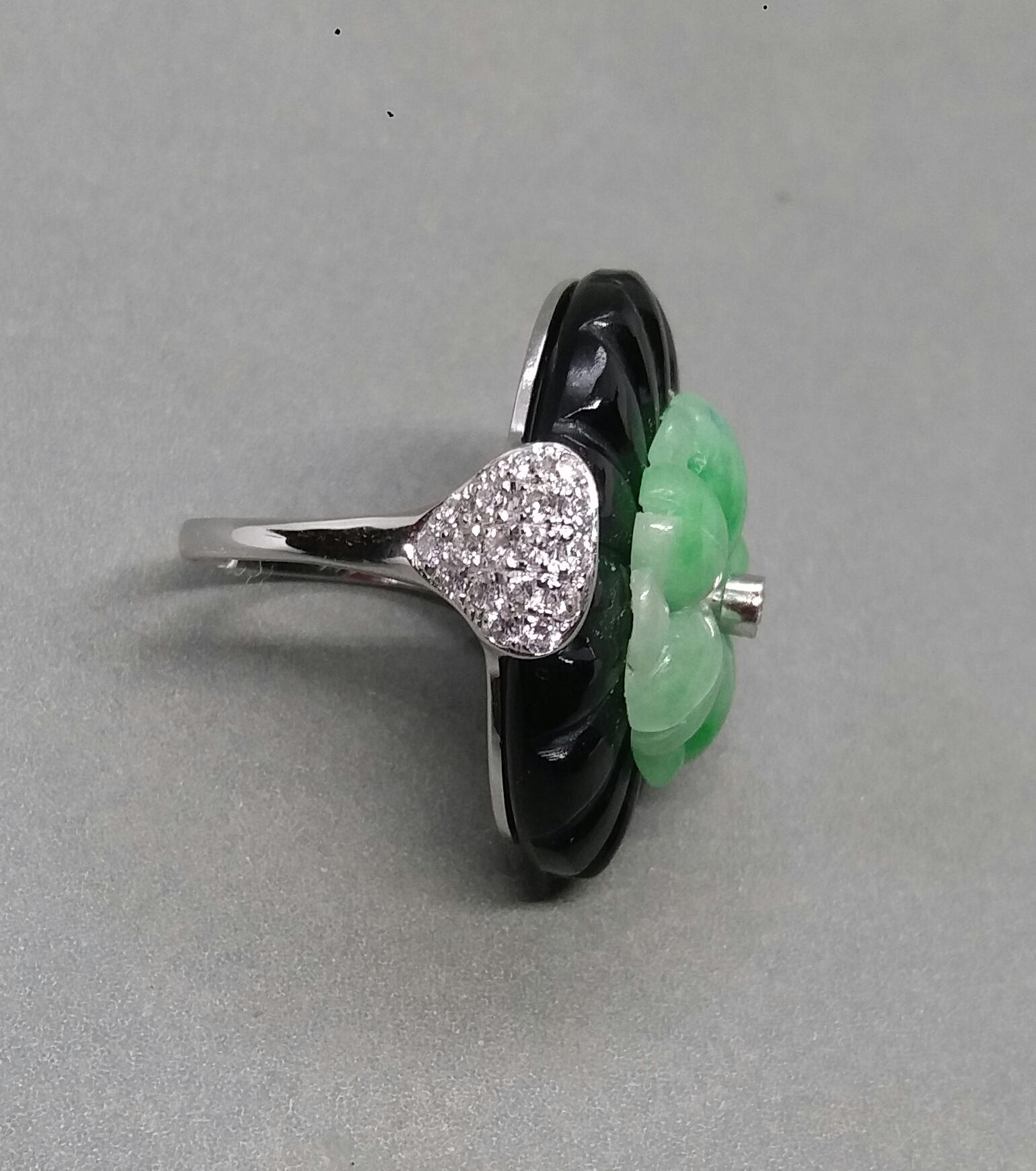 Classic and elegant ring composed of an oval engraved Black Onyx cabochon surmounted by a stylized Burmese jade round flower with a small diamond in the center...The shank  is also in 14k  White Gold with 2 pear shape pave' of 34 full cut diamonds