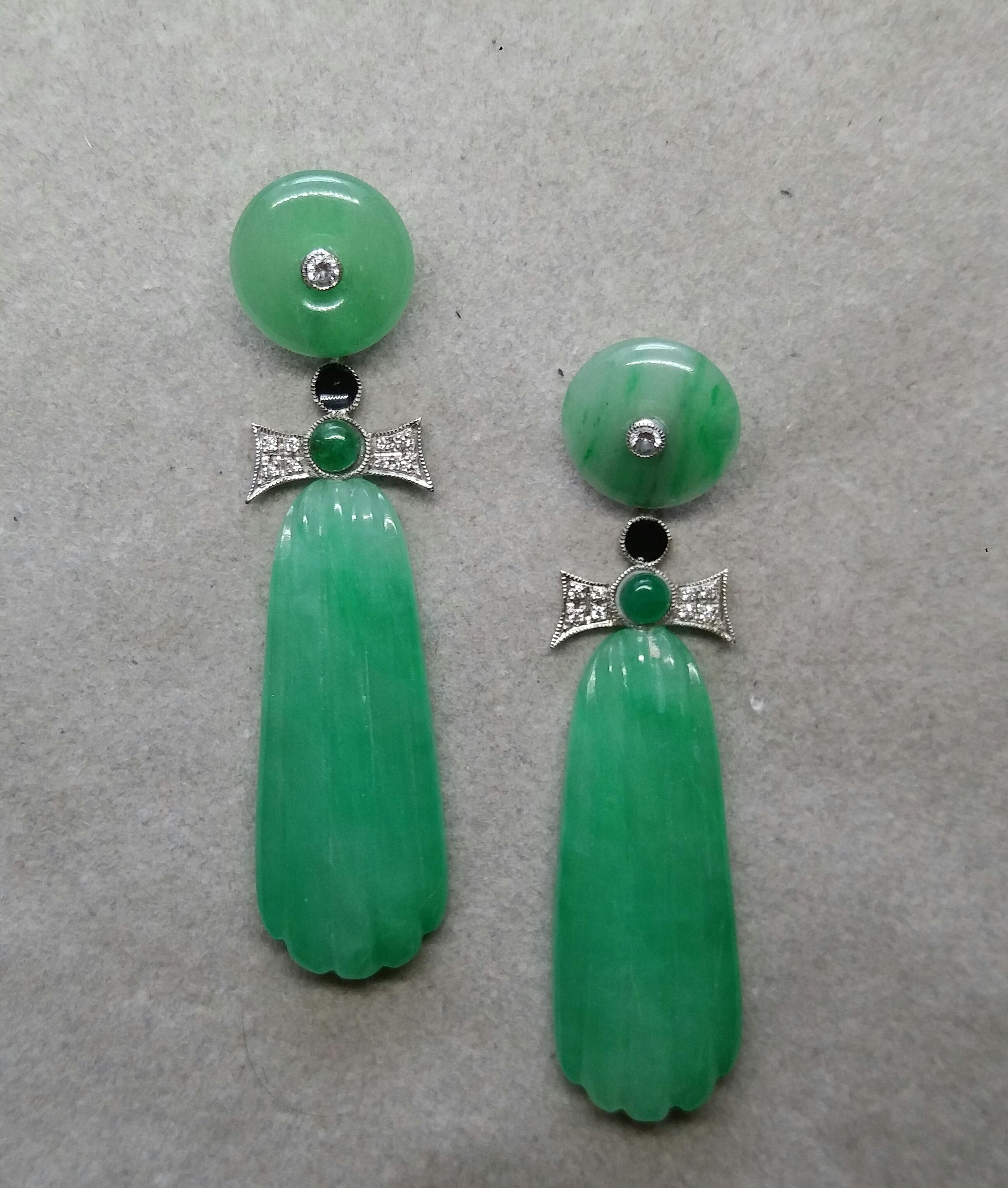 In these classic Art Deco Style earrings we have the tops with 2 Jade discs with small diamonds set in gold in the center ,the middle parts are composed of  2 elements in White Gold, Diamonds small round Emerald cabs and Black Enamel,while in the