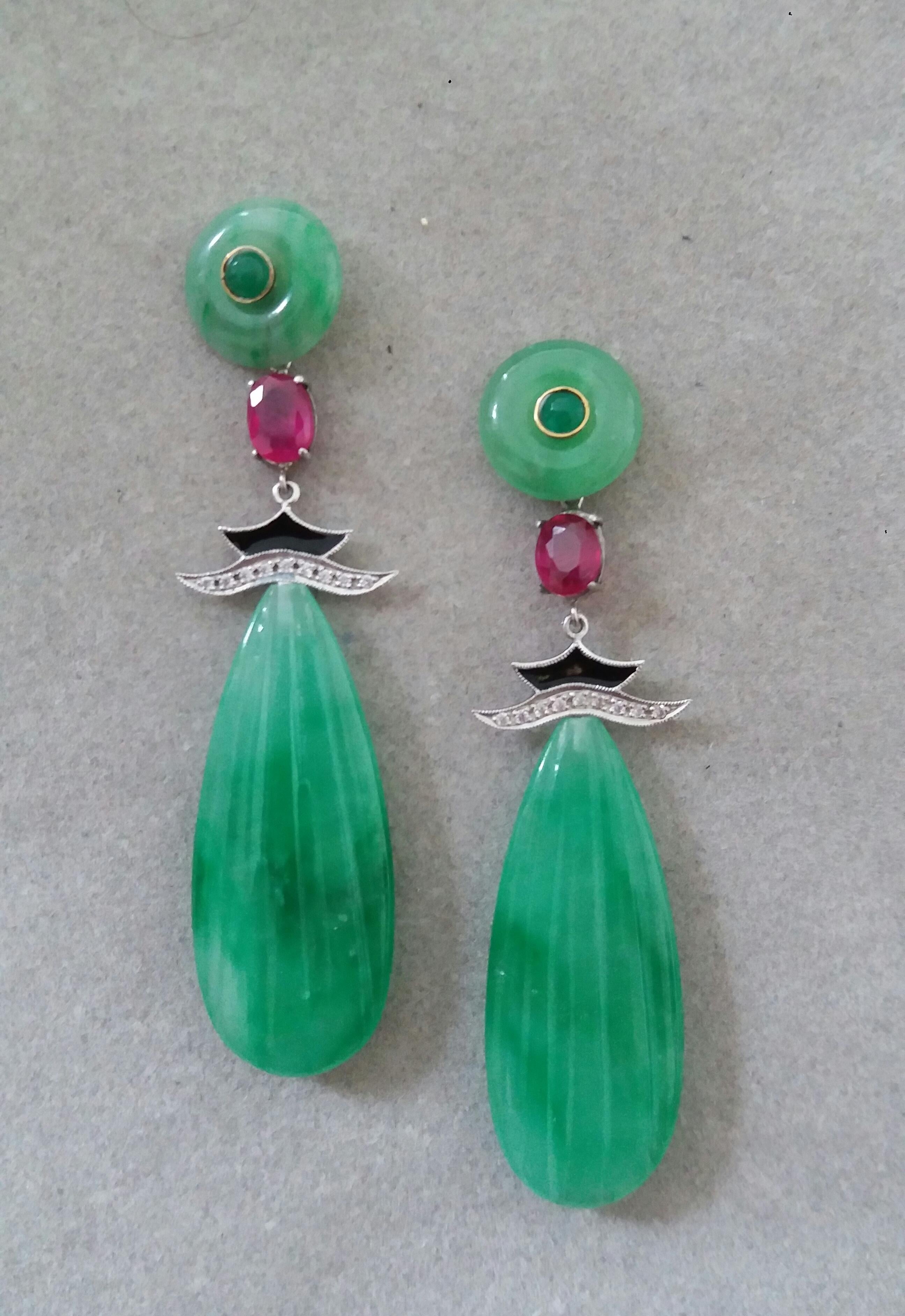 In these classic Art Deco Style earrings we have the tops with 2 Jade discs with small round Emerald cabs set in gold in the center ,the middle parts are composed of 2 Oval faceted Rubies measuring 6x8 mm and 2 elements in White Gold, Diamonds and