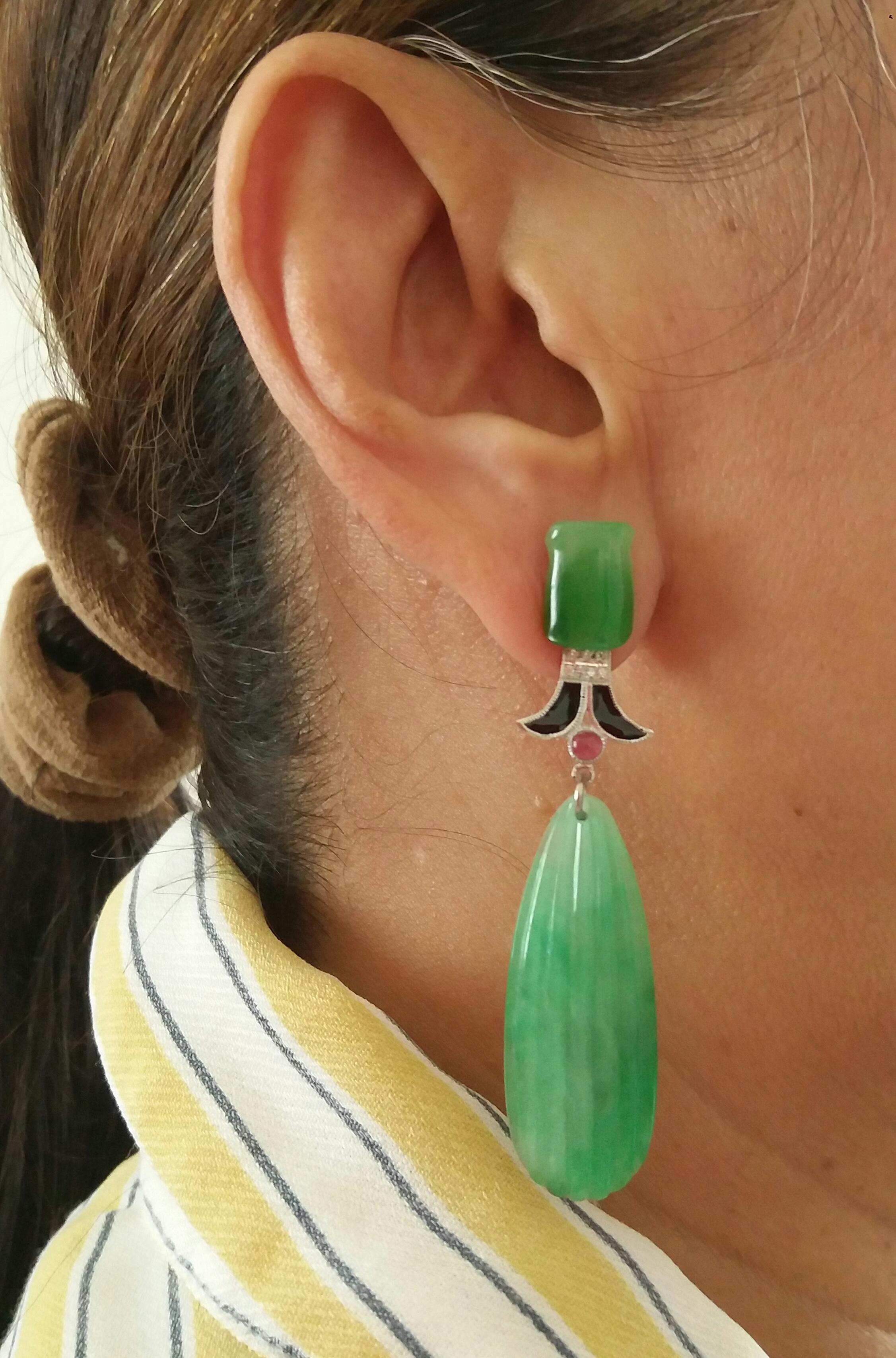 In these classic Art Deco Style earrings we have the tops with 2 Bamboo shape Jades ,the middle parts are composed of 2 elements in White Gold ,Rubies, Diamonds and Black Enamel,while in the bottom parts we have 2 engraved Burma Jade flat drops

In