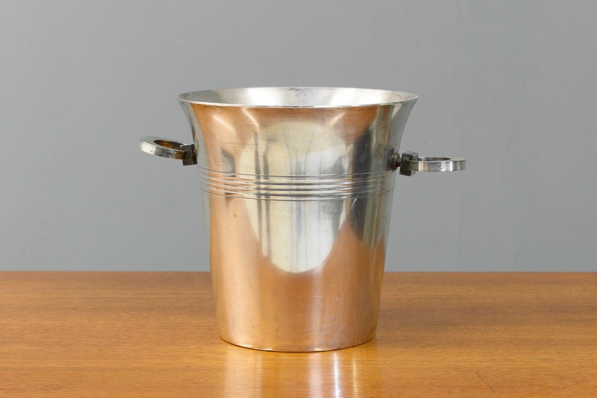 Art Deco style silver plated champagne bucket with squared circular handles. Stamped underneath. Circa 1950.
H 20cm x W 20cm x D 20cm