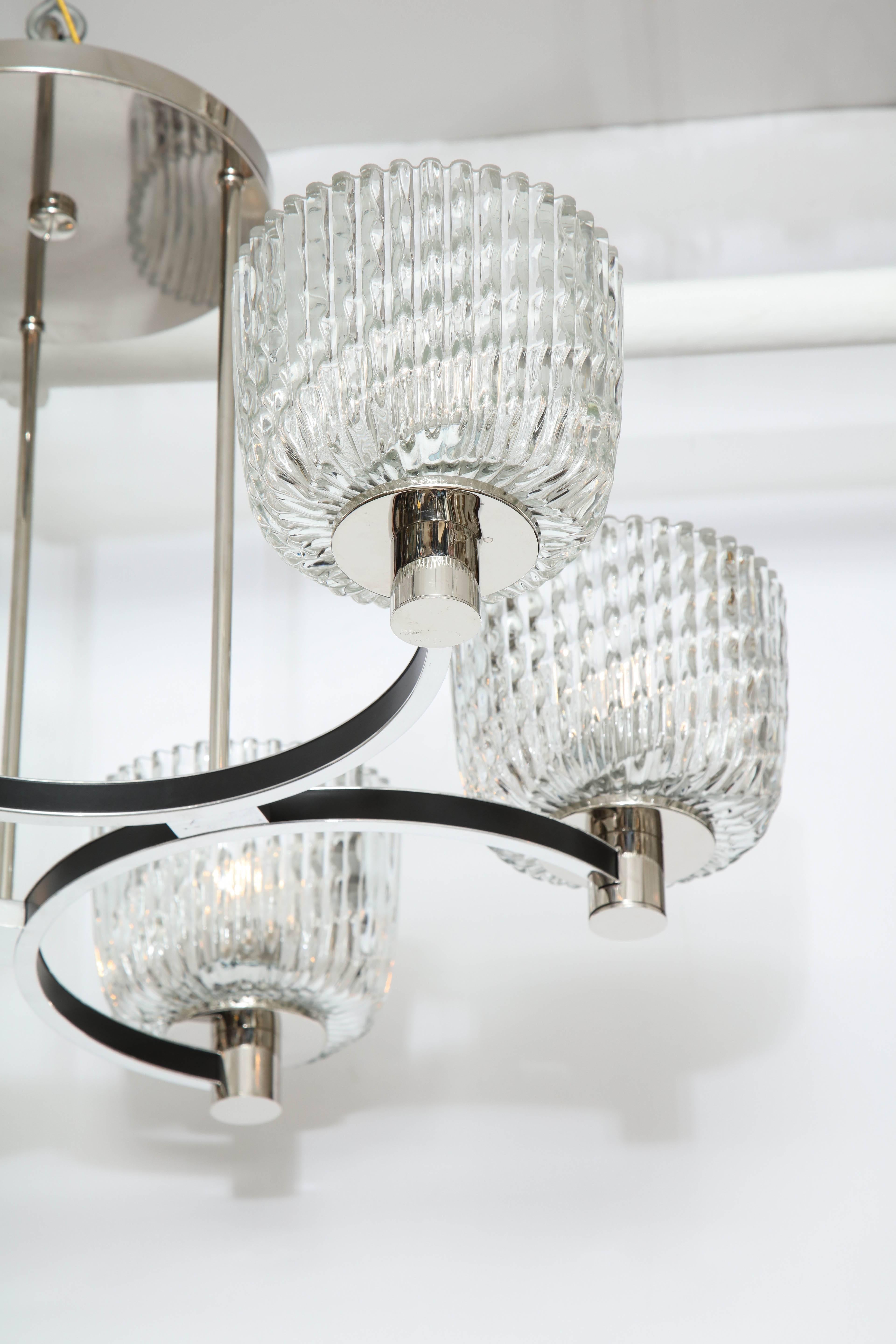 Beautiful Art Deco influenced style chandelier.
The polished chrome frame supports six large rippled glass shades. The fixture has been newly rewired for the US and takes standard size light bulbs (40 watts per socket).