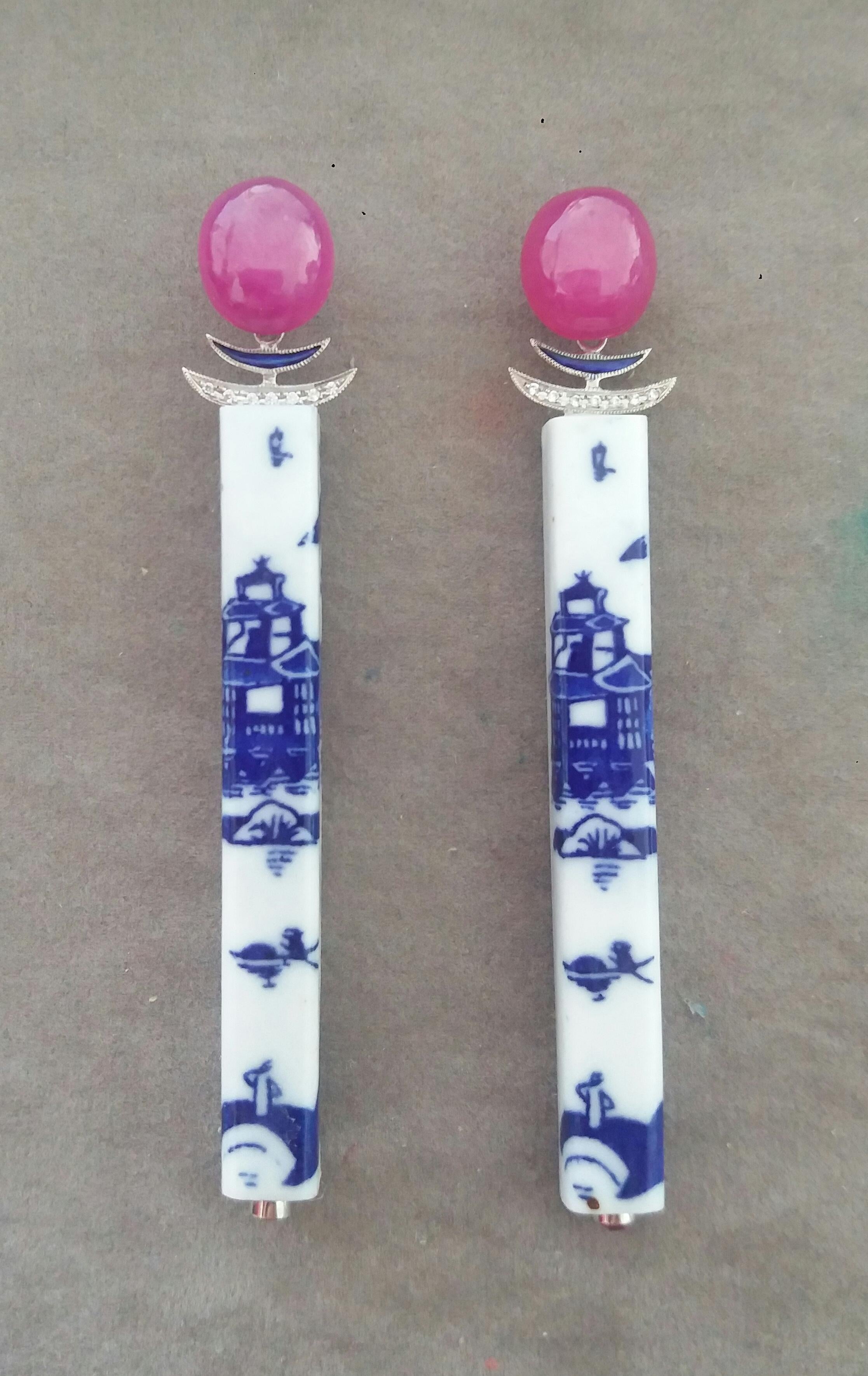 In these Unique Earrings we have 2 sticks of Chinese Ceramic 62 mm. long ,depicting a landscape with a Temple , suspended to 2 Ruby cabs measuring 11x12 mm and 2 elements in white gold, blue enamels and 14 small full cut diamonds.

In 1978 our