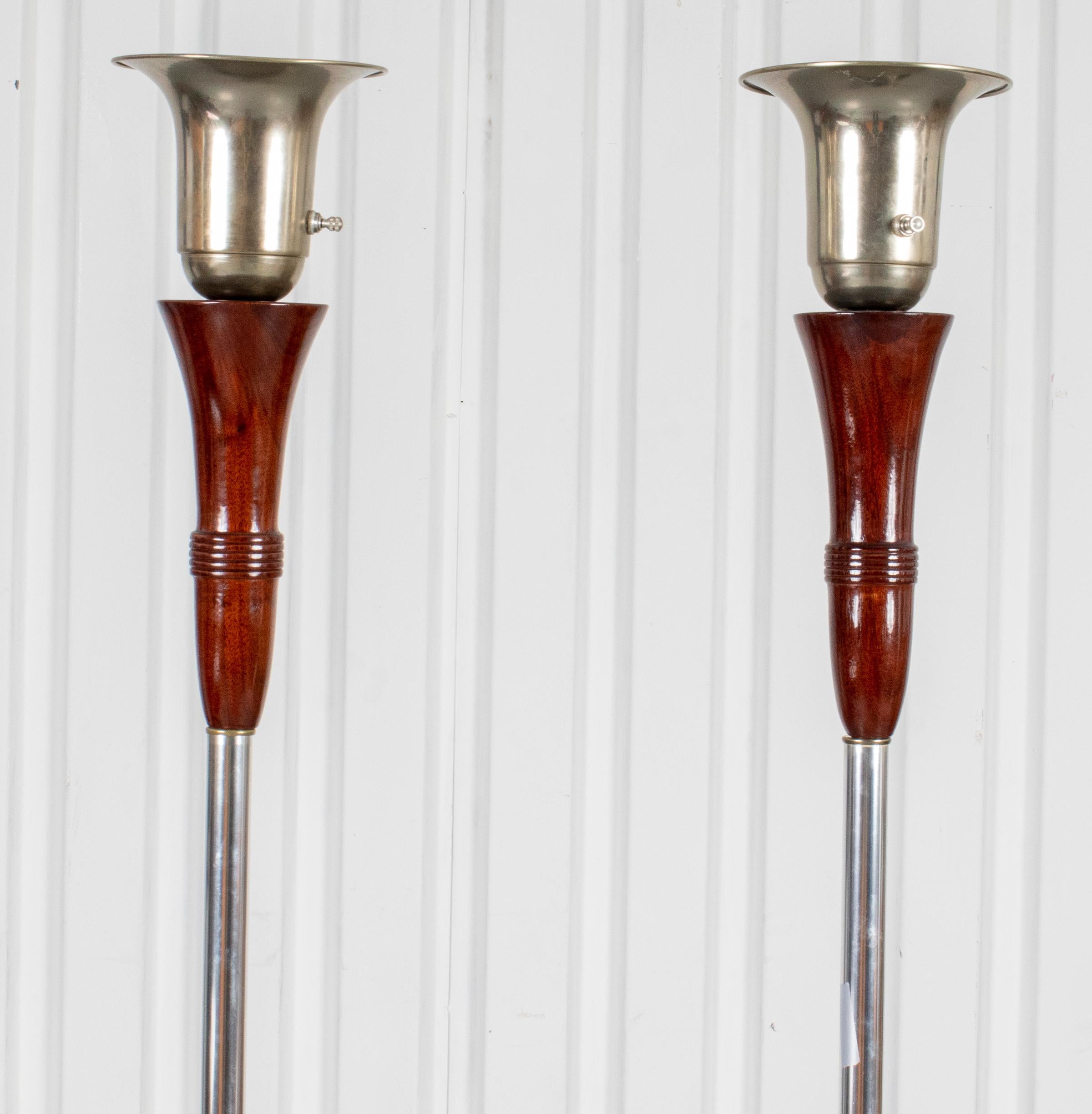 Pair of Art Deco style modern chrome and wood floor torchiere floor lamps. Measures: 65.25” Height x 10” diameter.