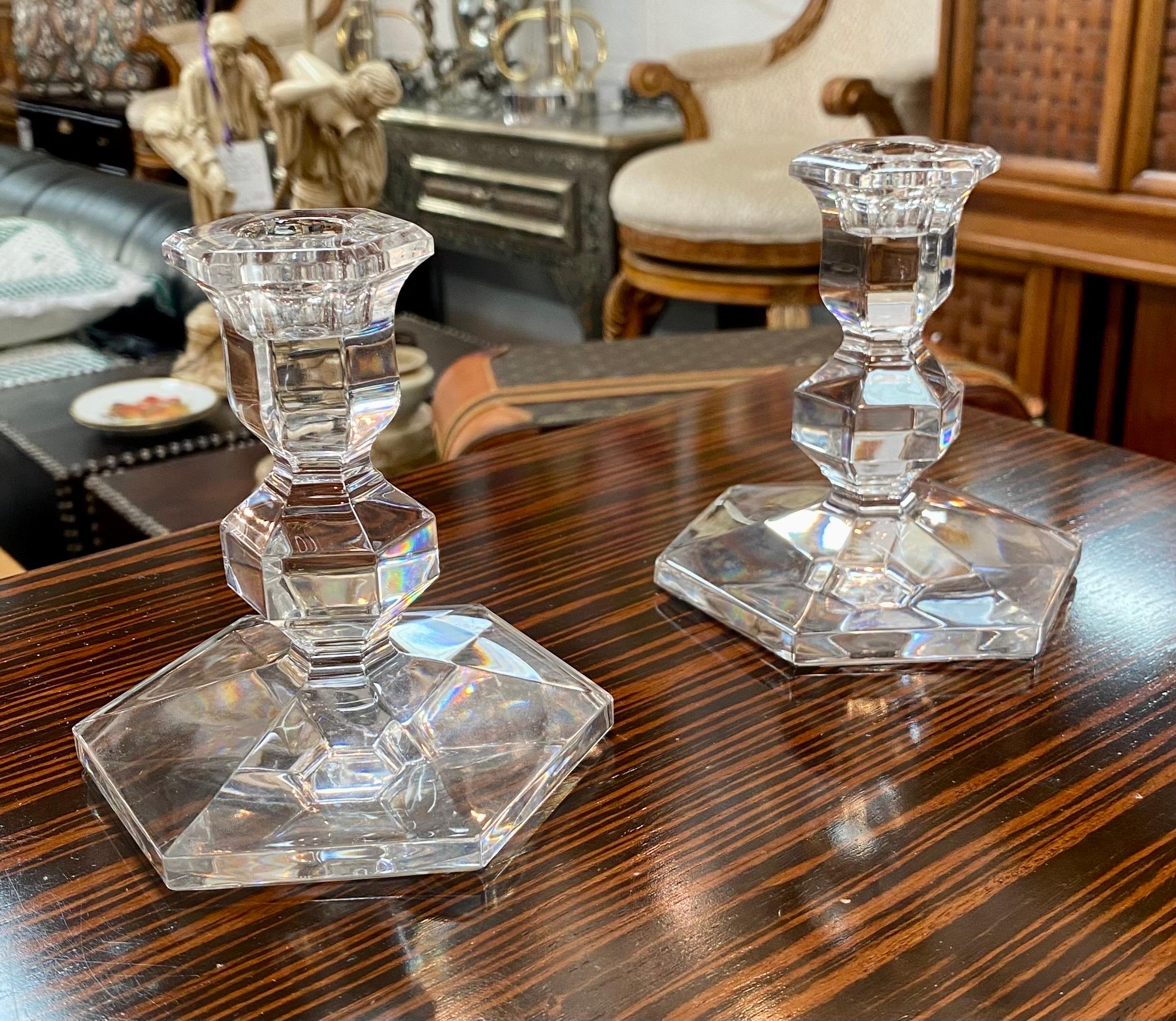An elegant pair of Art Deco style clear crystal candlestick holders featuring an hexagon shape base and sconce. The stem is short and shows a diamond shape adding style and charm to this pair of candleholders. The candlesticks are signed Val St