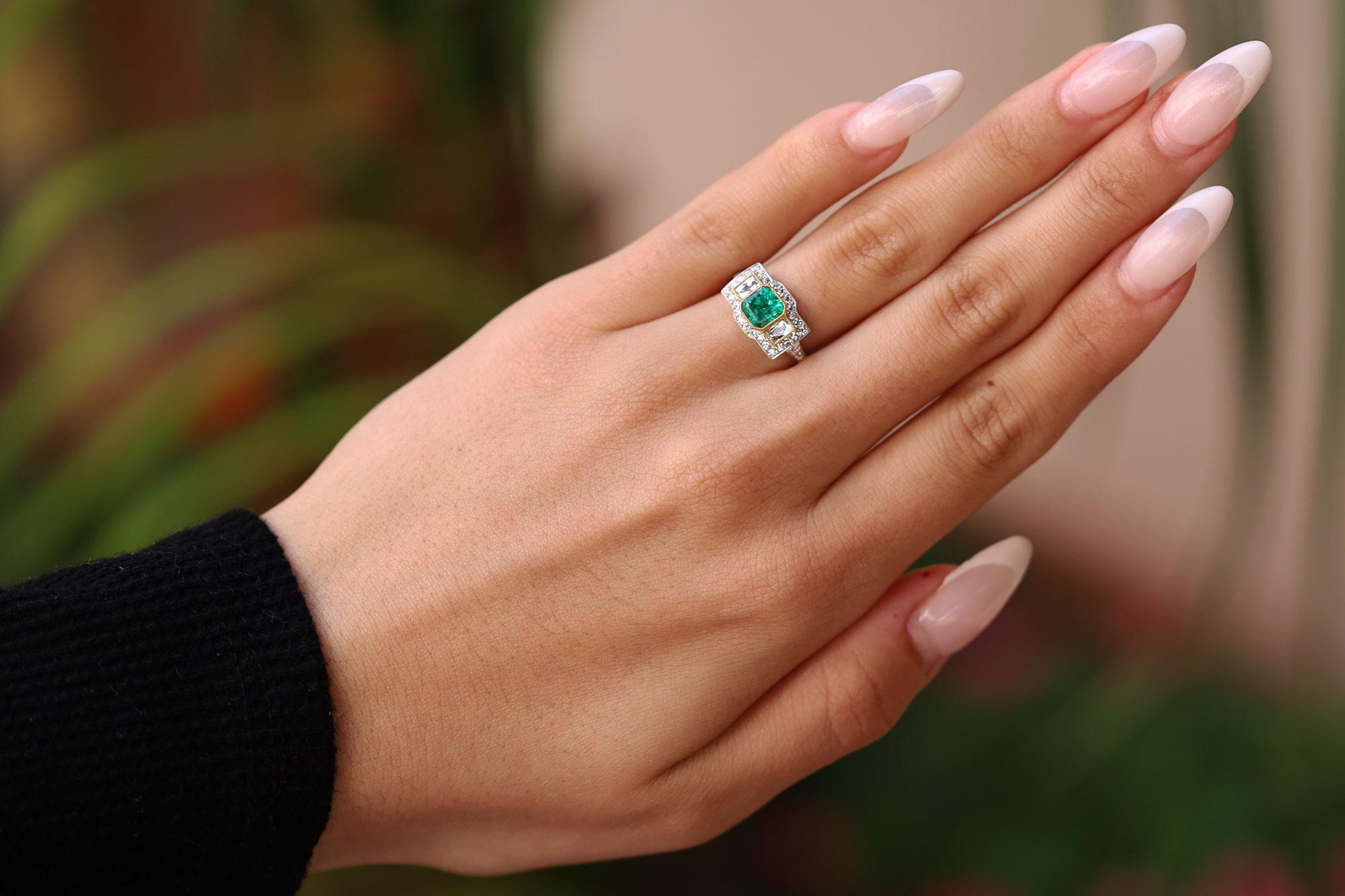 The Gainsboro Art Deco revival Colombian emerald and diamond 3 stone engagement ring is a bespoke treasure. The glowing, verdant emerald is deeply saturated with a vibrant green, tastefully accented by a pair of step cut baguettes and ensconced in a