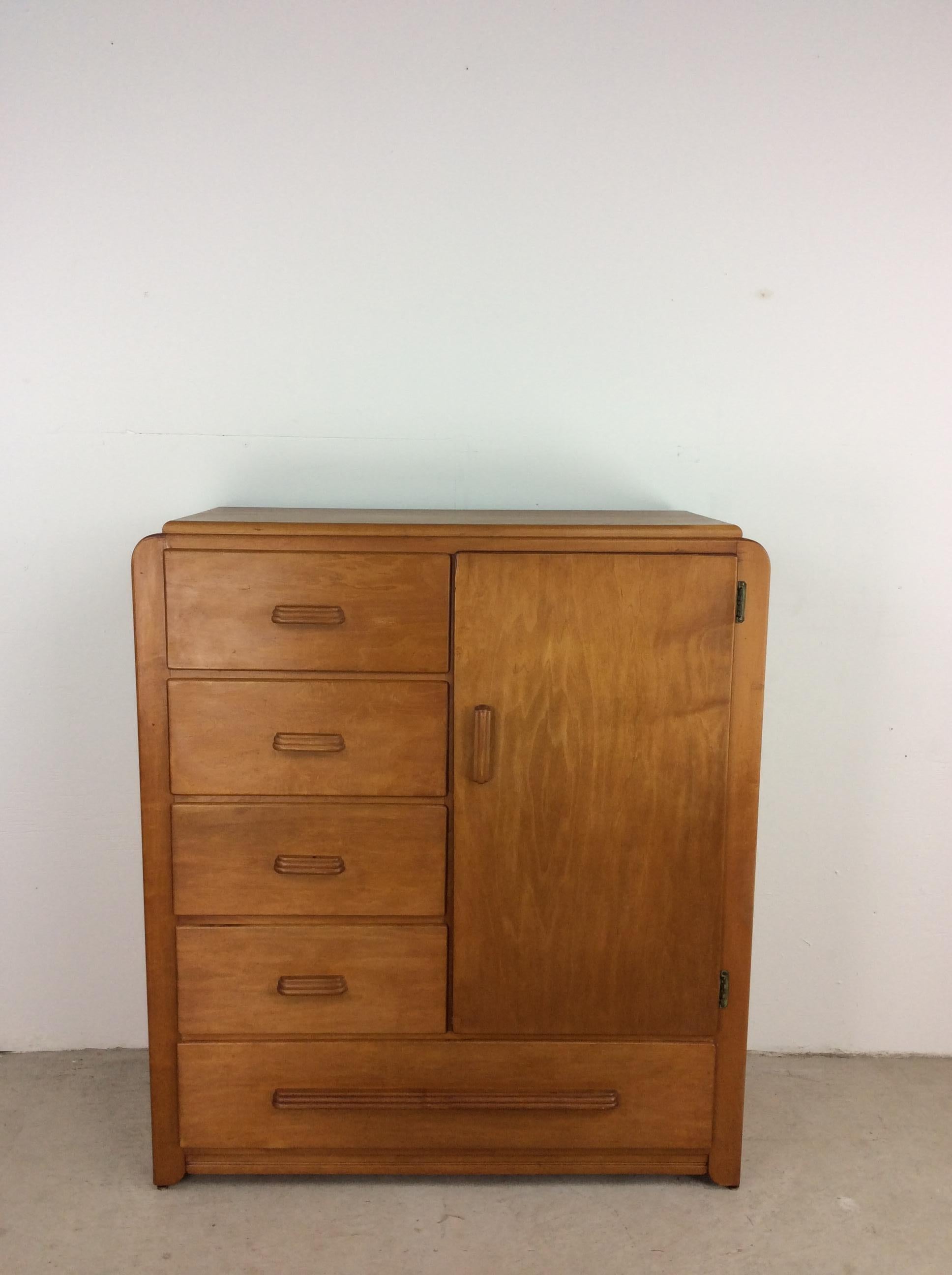 This Art Deco style compact armoire features original blonde finish in the style of Heywood Wakefield, five dovetailed drawers, cabinet with a rod for hanging shirts, and carved wood pulls.

Dimensions: 38w 15.5d 43.5h.


.