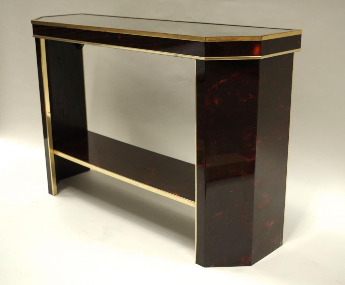 Art Deco style console rectangular form with cut sides and a spacer tablet. Decoration under altuglas painted in a tortoiseshell way and adorned with gilt brass ornaments.
Work made circa 1980.