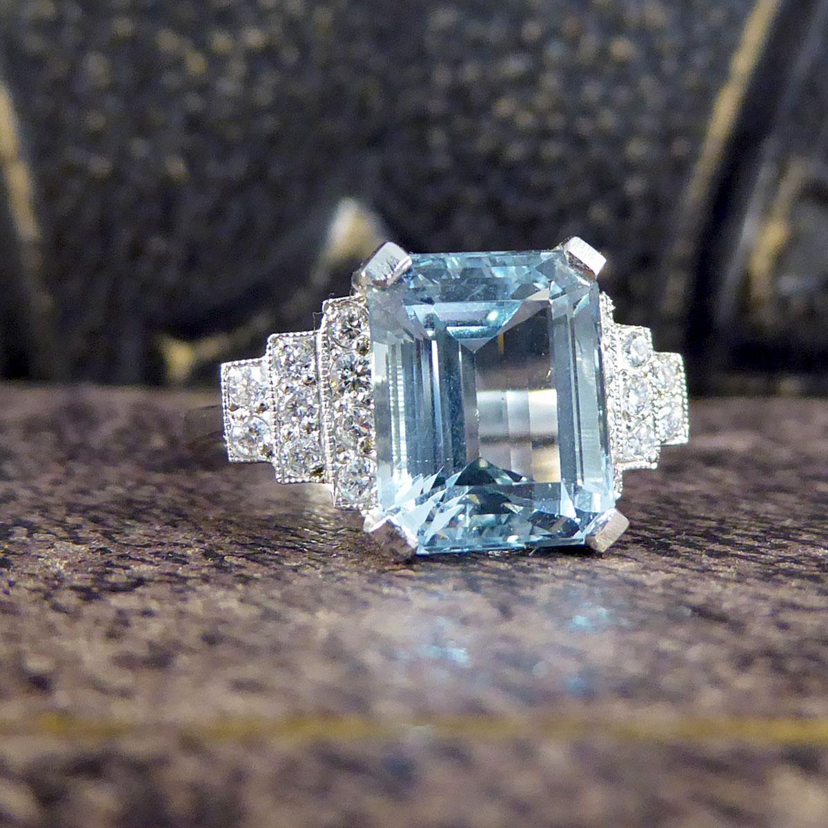 Dieser absolut atemberaubende Ring enthält einen 3,30ct schönen Aquamarin im Smaragdschliff. Auf jeder Schulter sitzt eine horizontale Pyramide aus Diamanten im Brillantschliff, am nächsten zum Aqua sind es vier Steine, dann drei und schließlich