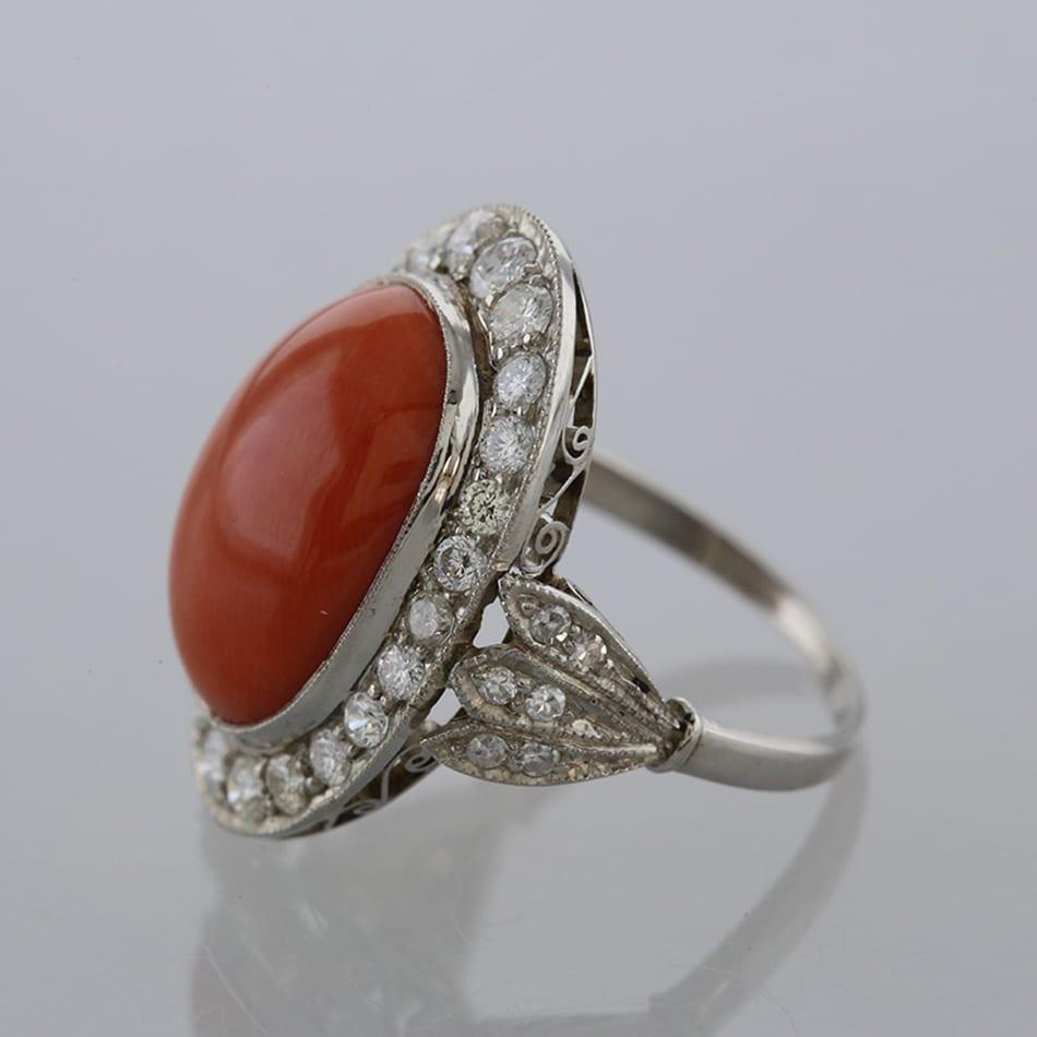 Nous avons ici une magnifique bague à grappes de coraux et de diamants qui rend parfaitement hommage à un style célèbre pendant le mouvement Art déco. Le point central de cette pièce en platine est un grand corail de forme ovale entouré d'une rangée