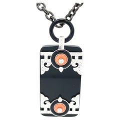 Ciondolo in stile Art Deco con corallo, diamanti, onice e oro bianco con catena in acciaio