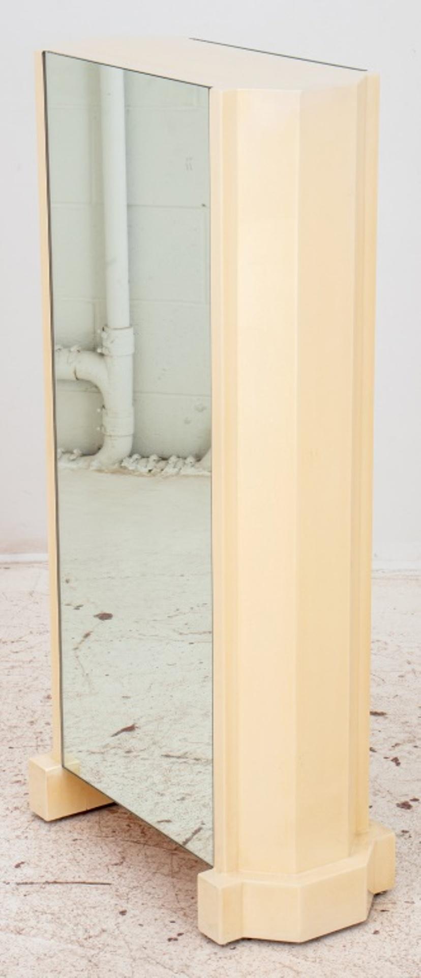 Hollywood Regency style cream lacquered pedestal having hexagonal skyscraper shape with mirrors on two sides. Measures: 42.5