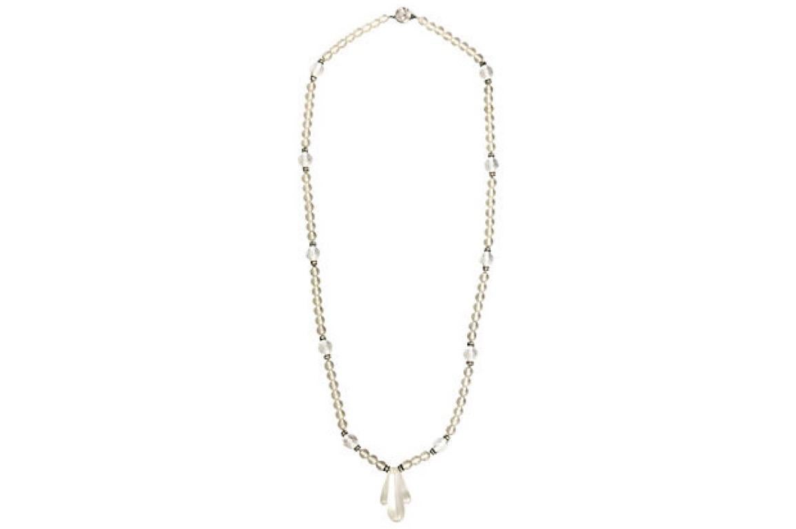 Deco-style crystal necklace featuring carved dropped center section on a strand of frosted crystal beads with facetted actions with crystal rondels. The necklace terminates into a push clasp. The clasp is marked with an H inside a C. Age wear.