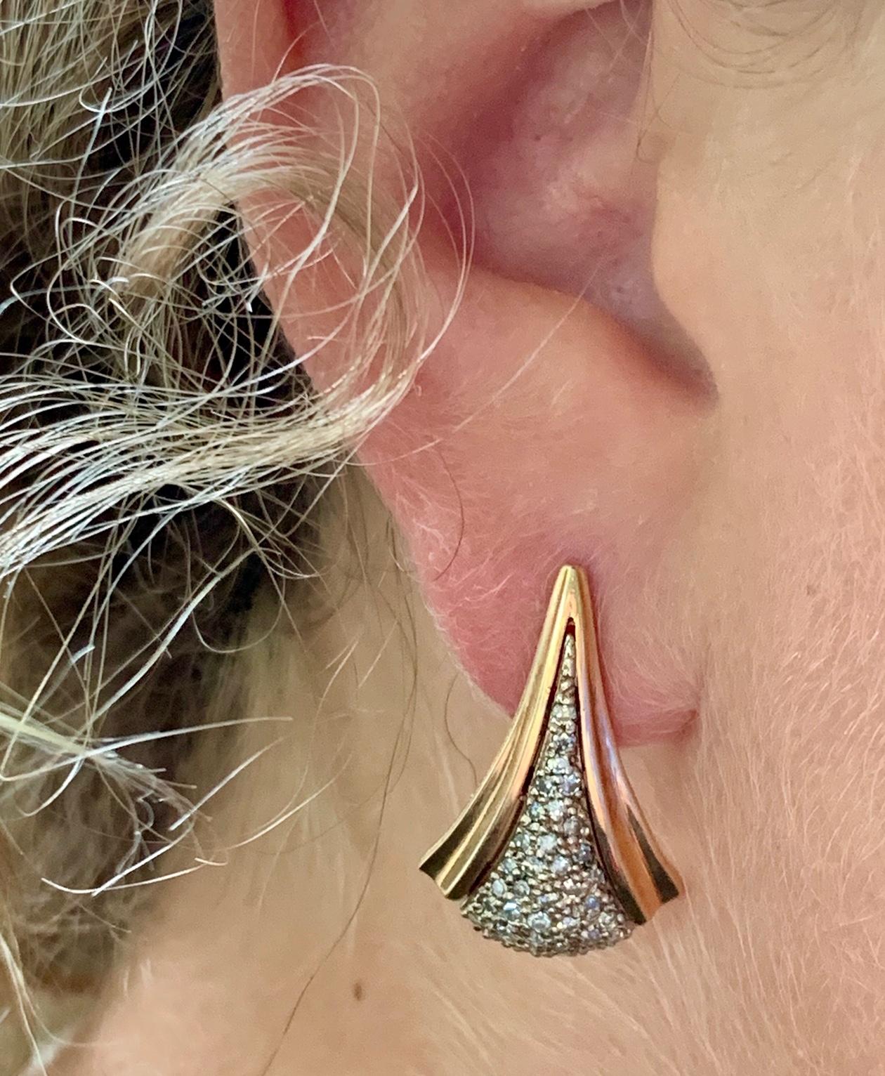 These are striking, modern 14k yellow gold fashion pierced earrings in the Art Deco style with a field of round cut diamonds surround by sweeping gold fans. 

There is no visible stamp.

The diamonds are .50 ctw.