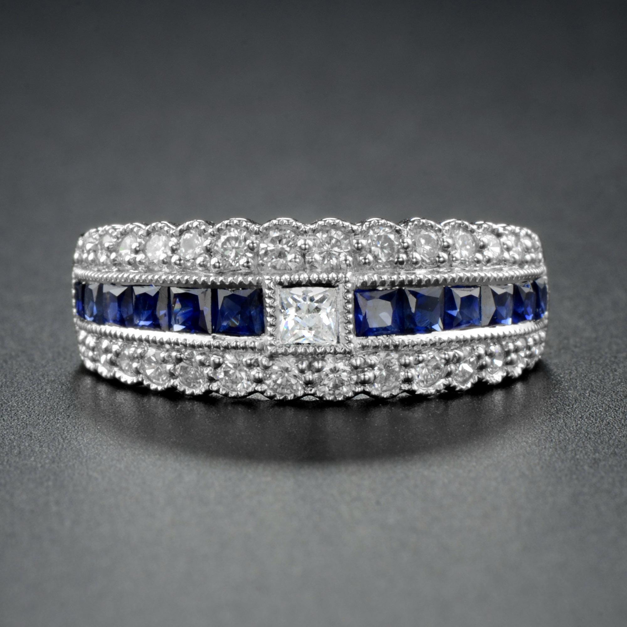 This absolutely superb example of the Art Deco design is a classy ring. A center diamond is accent by twelve French cut natural blue sapphire on east and west of this striking half eternity ring, with two further bands of white diamonds either side.