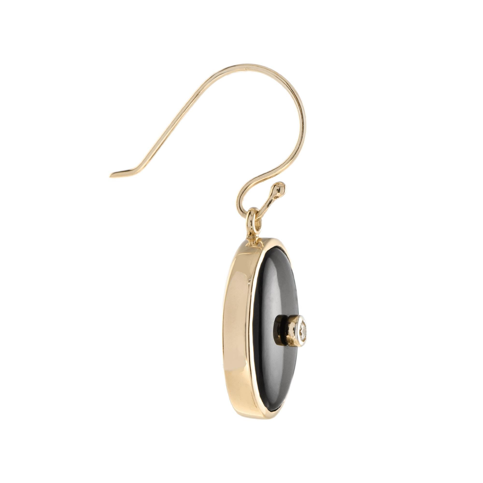 These eye catching bezel set diamond and onyx earrings will add a uniqueness to your outfit with the presence of onyx and a yellow gold movement hook. 

Information
Style: Art Deco
Metal: 14K Yellow Gold
Width: 13 mm.
Length: 31 mm.
Weight: 3.80 g.
