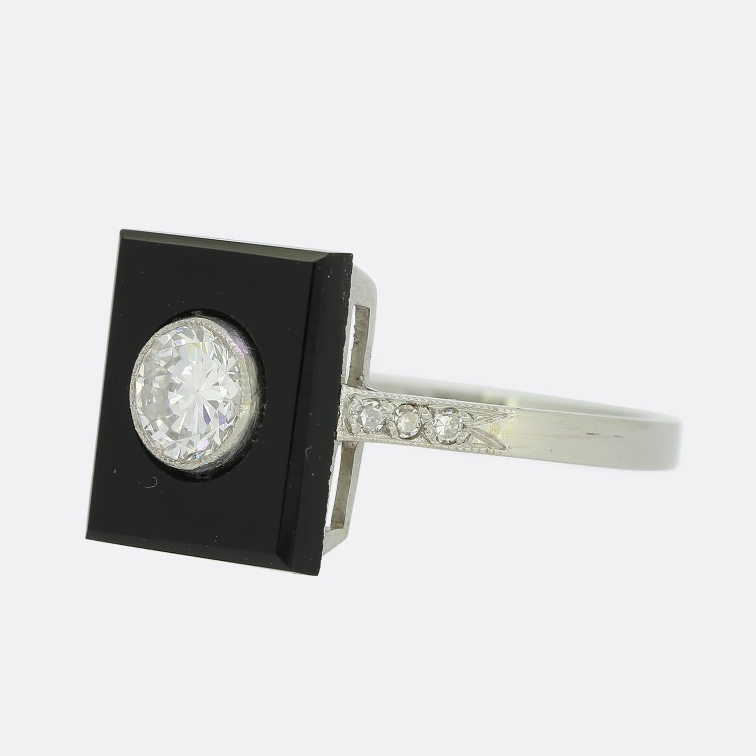 This is an Art Deco style onyx and diamond plaque ring. The central diamond is a 0.35 carat round brilliant cut and sits in a rubover mount with a lovely milgrain edge.

Condition: Used (Excellent)
Weight: 3.8 grams
Ring Size: K (50)
Face