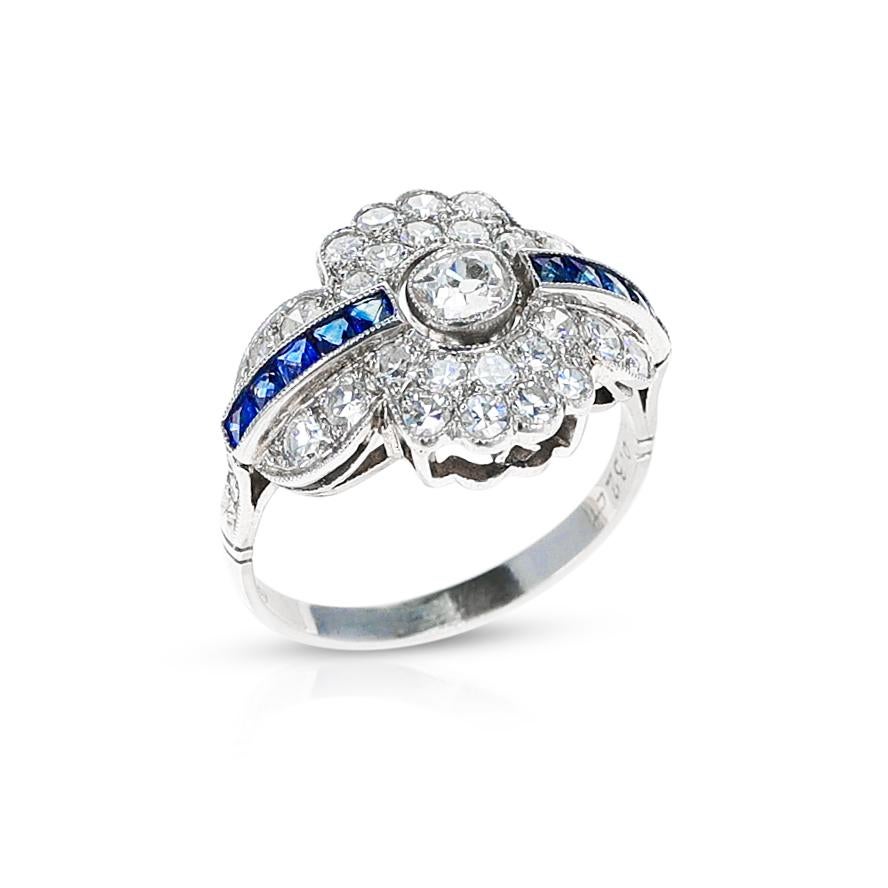 An Art Deco-Style Round Diamond and Sapphire Ring. The center stone is 0.32 carats. The total weight of the ring is 4.93 grams. The ring size is US 7.25. The ring is made in Platinum. 