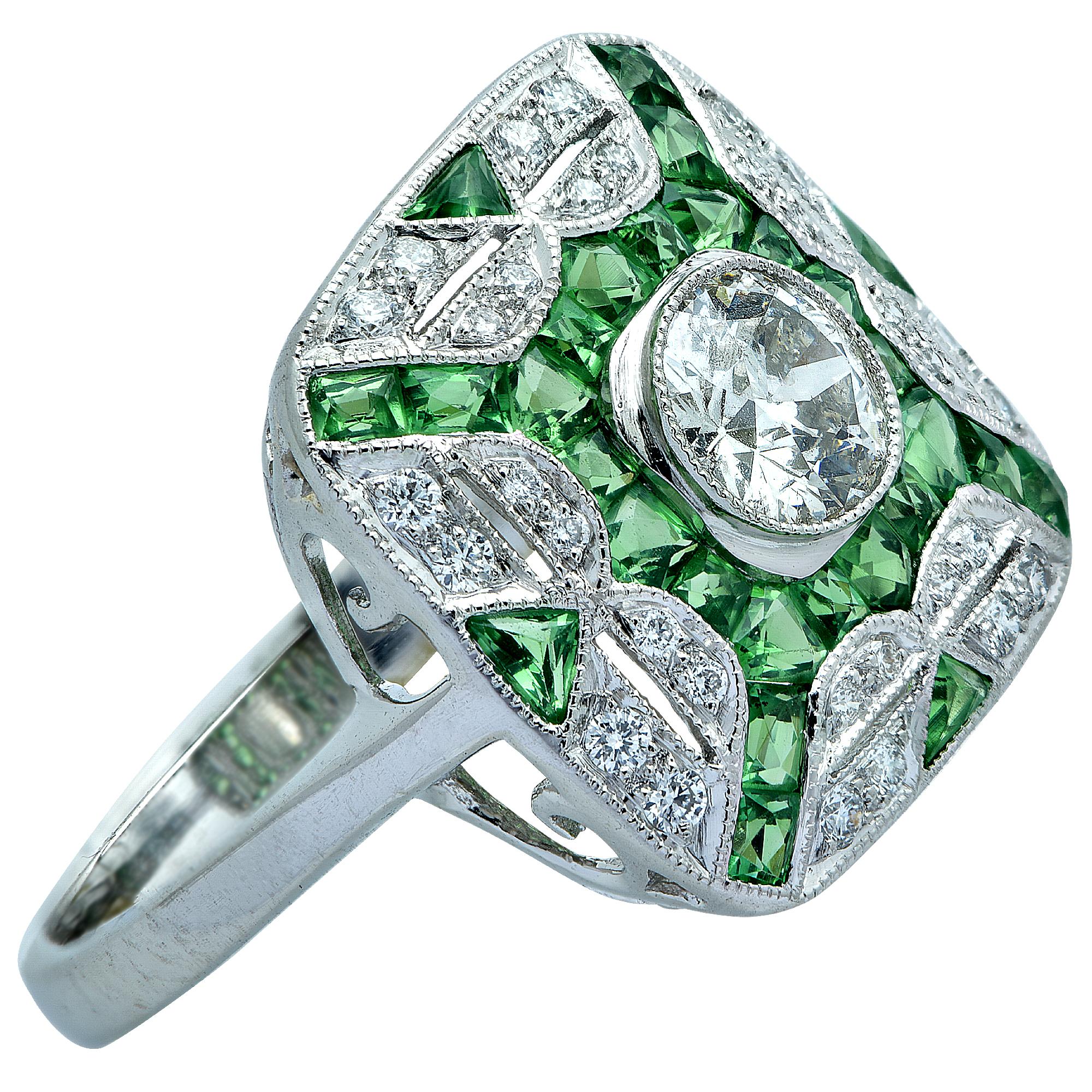 Art Deco Style ring crafted in Platinum featuring a European cut diamond weighing approximately .70 carats, I color and VS1 clarity, surrounded by 32 diamonds weighing approximately .40 carats total, and 24 vivid green tsavorite garnets weighing