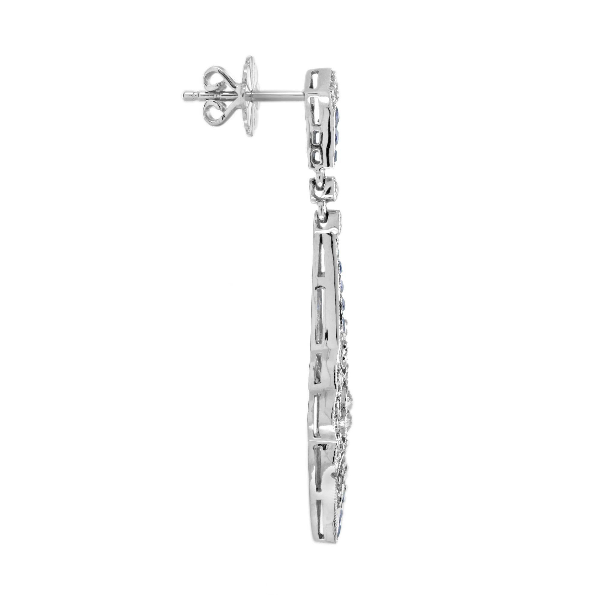 These eye-catching Art Deco style earrings are hand crafted with an intricately detailed geometric design. At the center of each earring, a round diamond is set together with shimmering diamond accent. These settings are elegantly hanging from