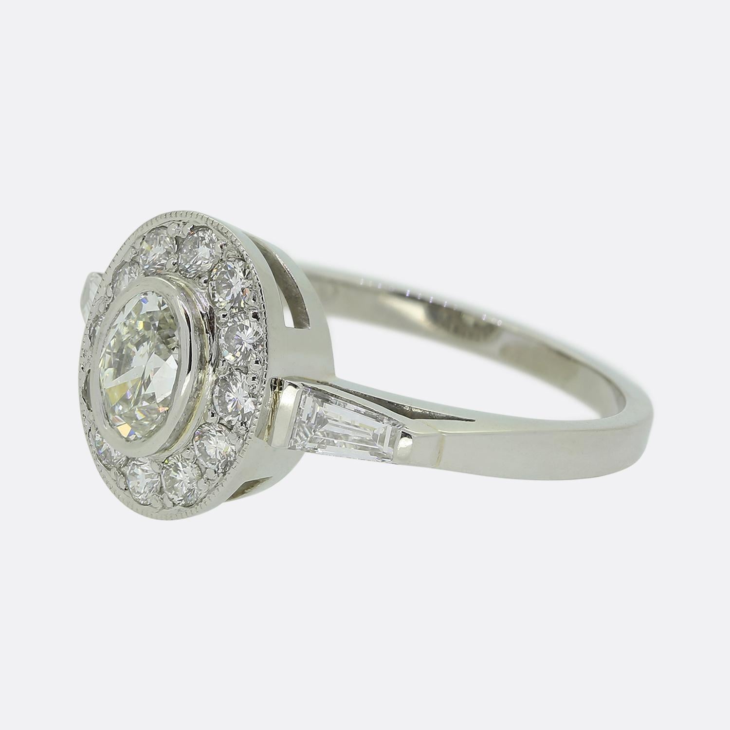Ecco un anello a grappolo meravigliosamente lavorato che rende perfettamente omaggio allo stile Art Deco. Questo pezzo in platino presenta un singolo diamante ovale sfaccettato al centro del quadrante, in un'ordinata incastonatura a castone. Questo