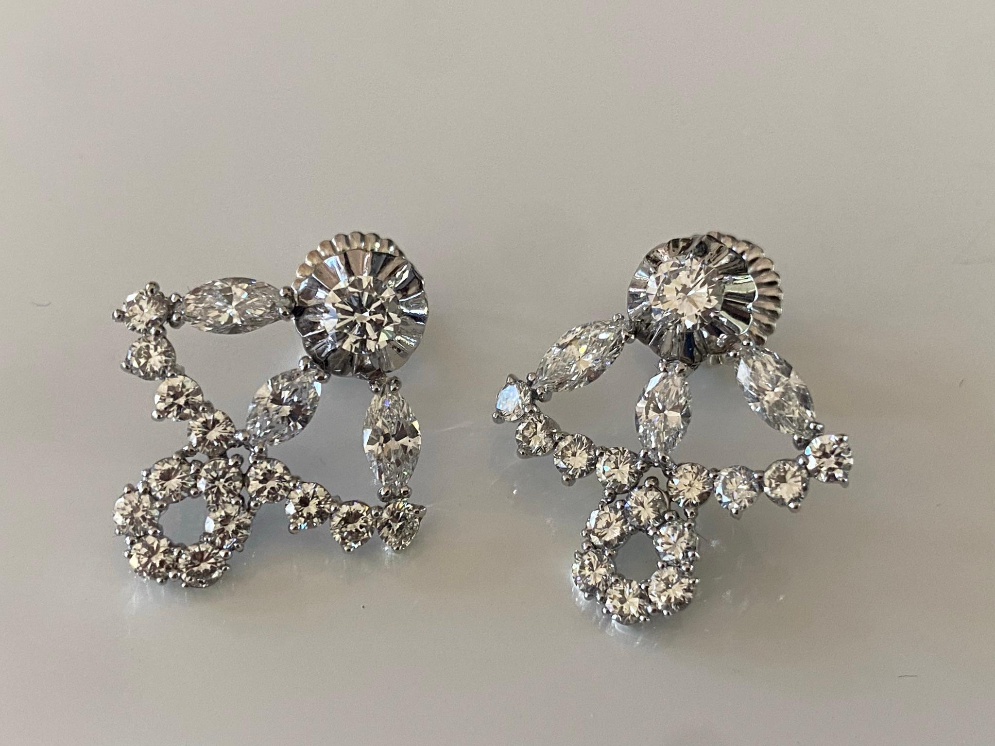 Exquisitely handcrafted in 18kt white gold, these custom-made 1920s Art Deco inspired earrings are designed around a dazzling array of round brilliant-cut and marquis-cut diamonds totaling 5.05 carats and measuring approximately 1 inch long. 
