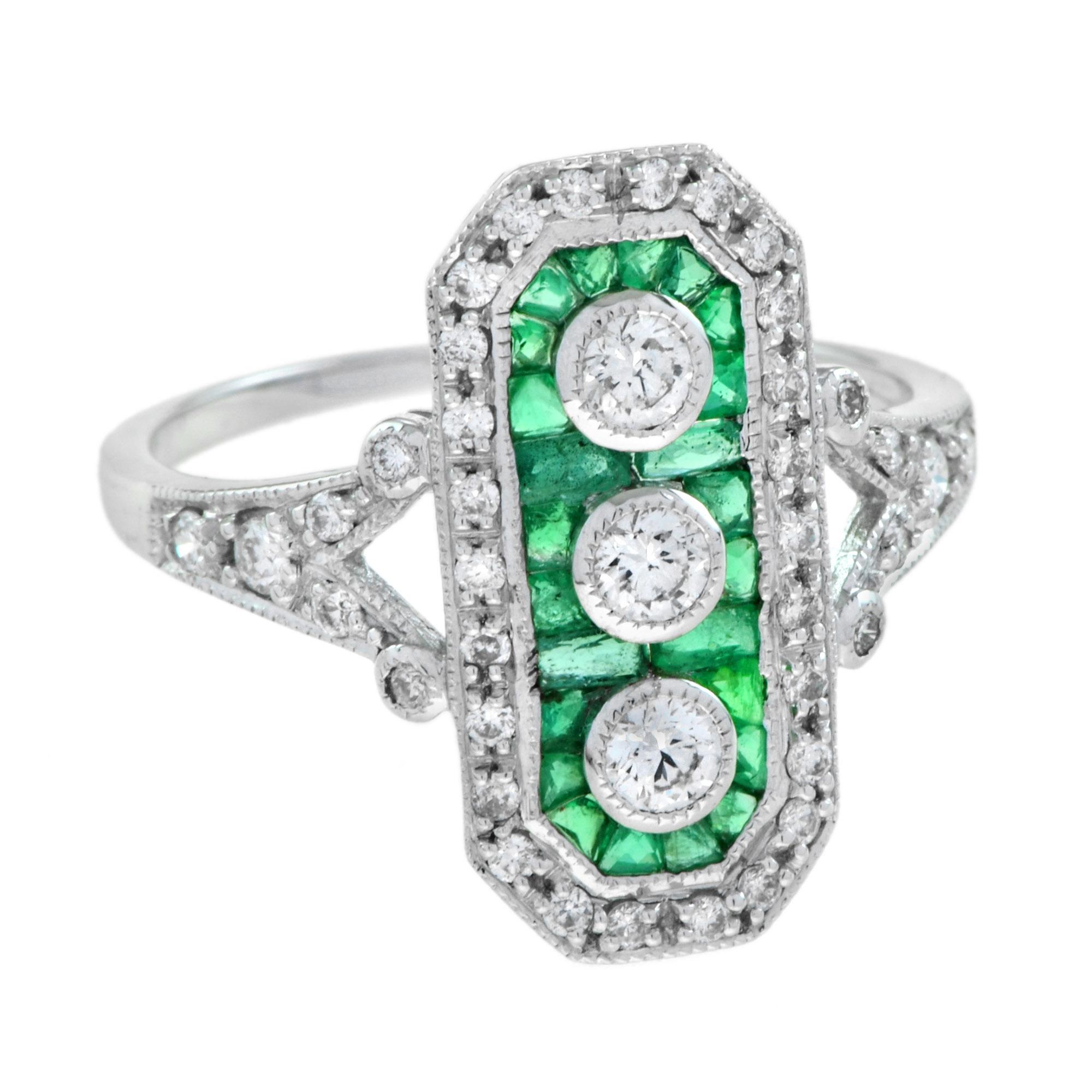 Trois diamants centraux de taille ronde créent un flash d'étincelles vertical et homogène dans cette superbe et impressionnante bague de style Art déco. Le trio scintillant est délimité par une monture octogonale en émeraudes et diamants qui mène à
