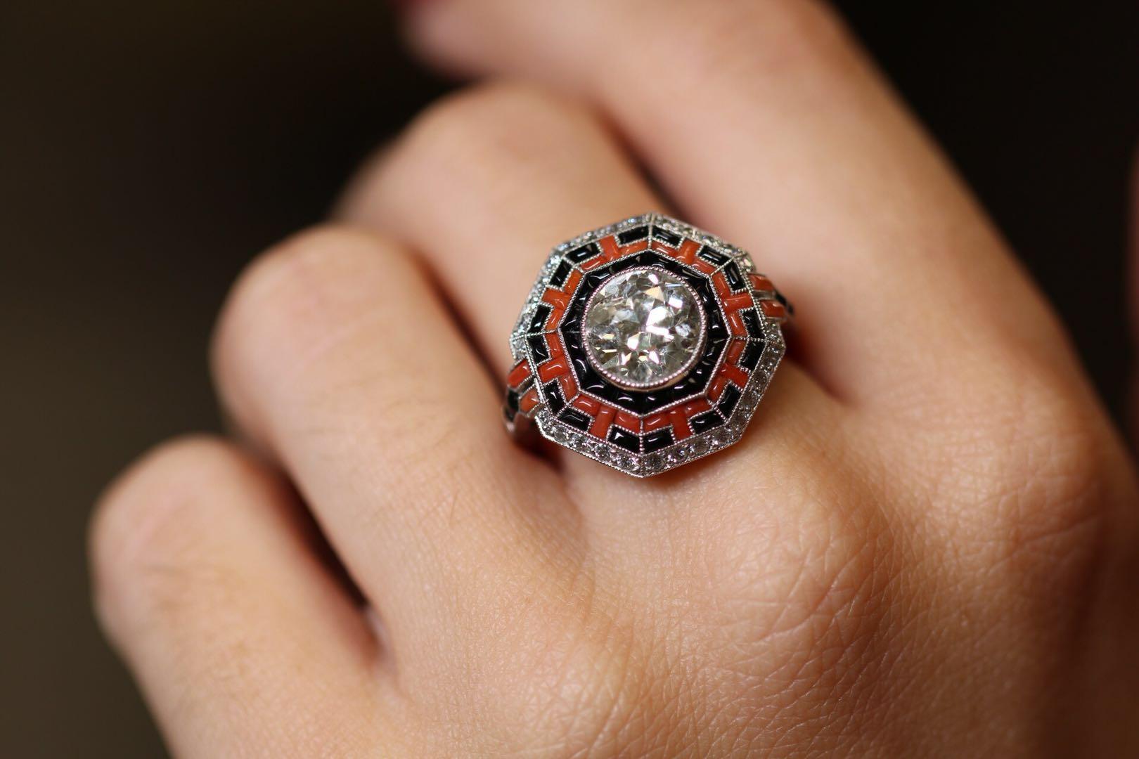 This ring captures the Art Deco period so well. The geometrical design centring on a large 2.23 carat old European cut diamond. The mix of coral and onyx pulls all your attention into the detailing of the work - like a micro mosaic maze.

A further